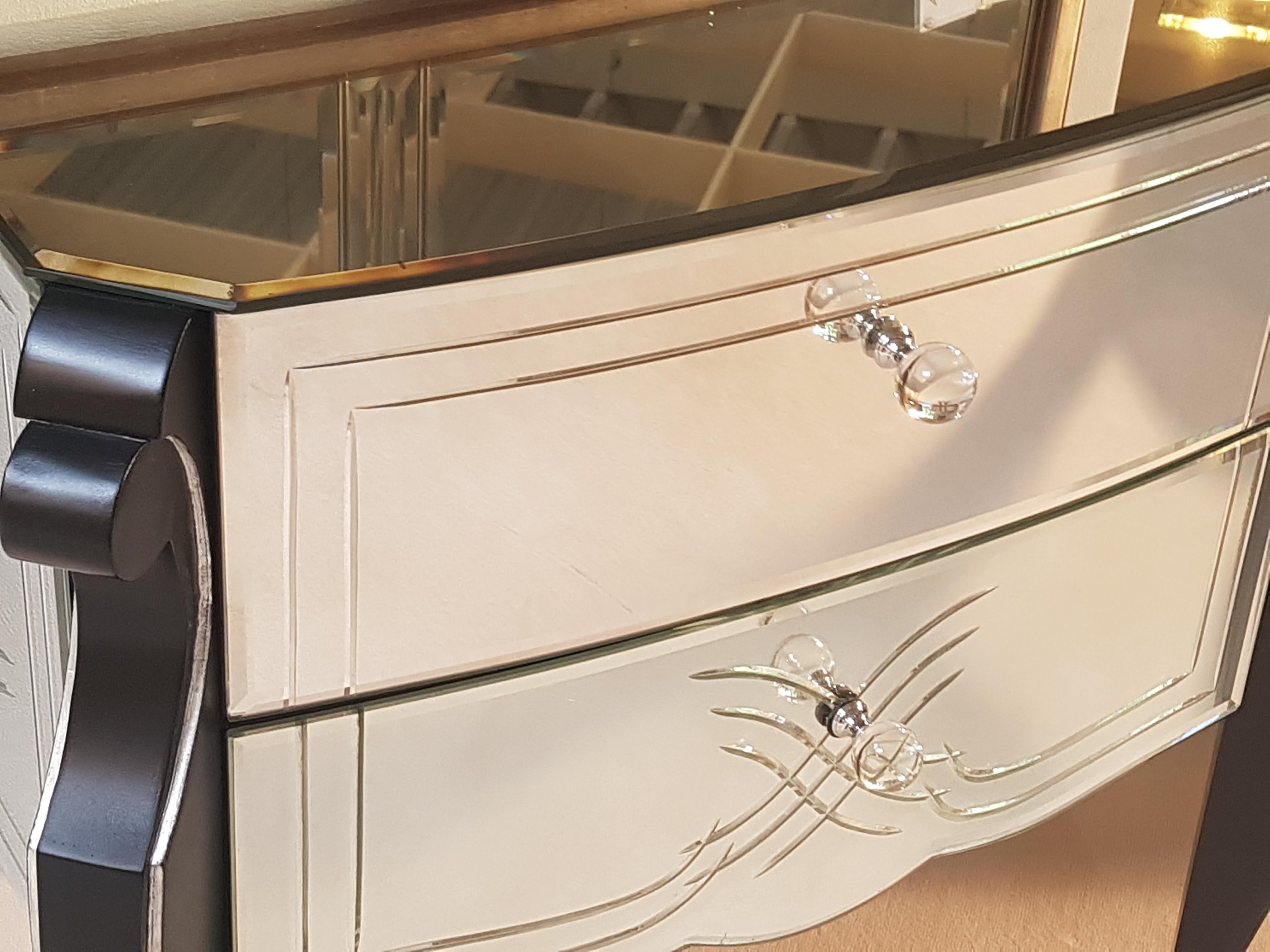 Amazing Italian commode with an all around mirror finish, fine ornamentation details and glass knobs. It features black lacquered curved legs in Biedermeier style with accented chrome bars. The interior of the two storage drawers is also painted