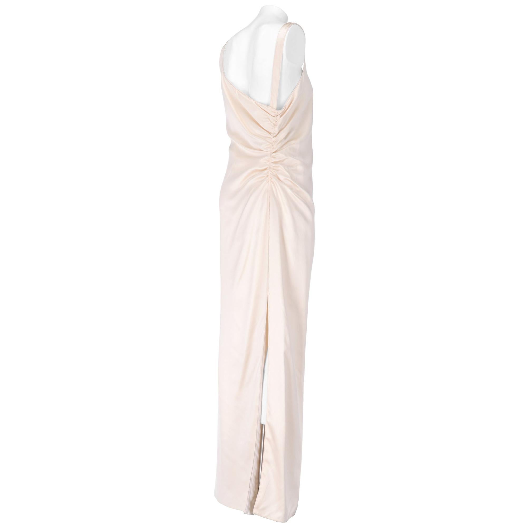 Ivory silk tailored wedding dress, long with straight skirt, side slit, asymmetrical neckline and curl on the left side. Zip and hook closure on the right side.

The product has never been worn.

Years: 1990s

Made in Italy 

Size: 46 IT

Linear