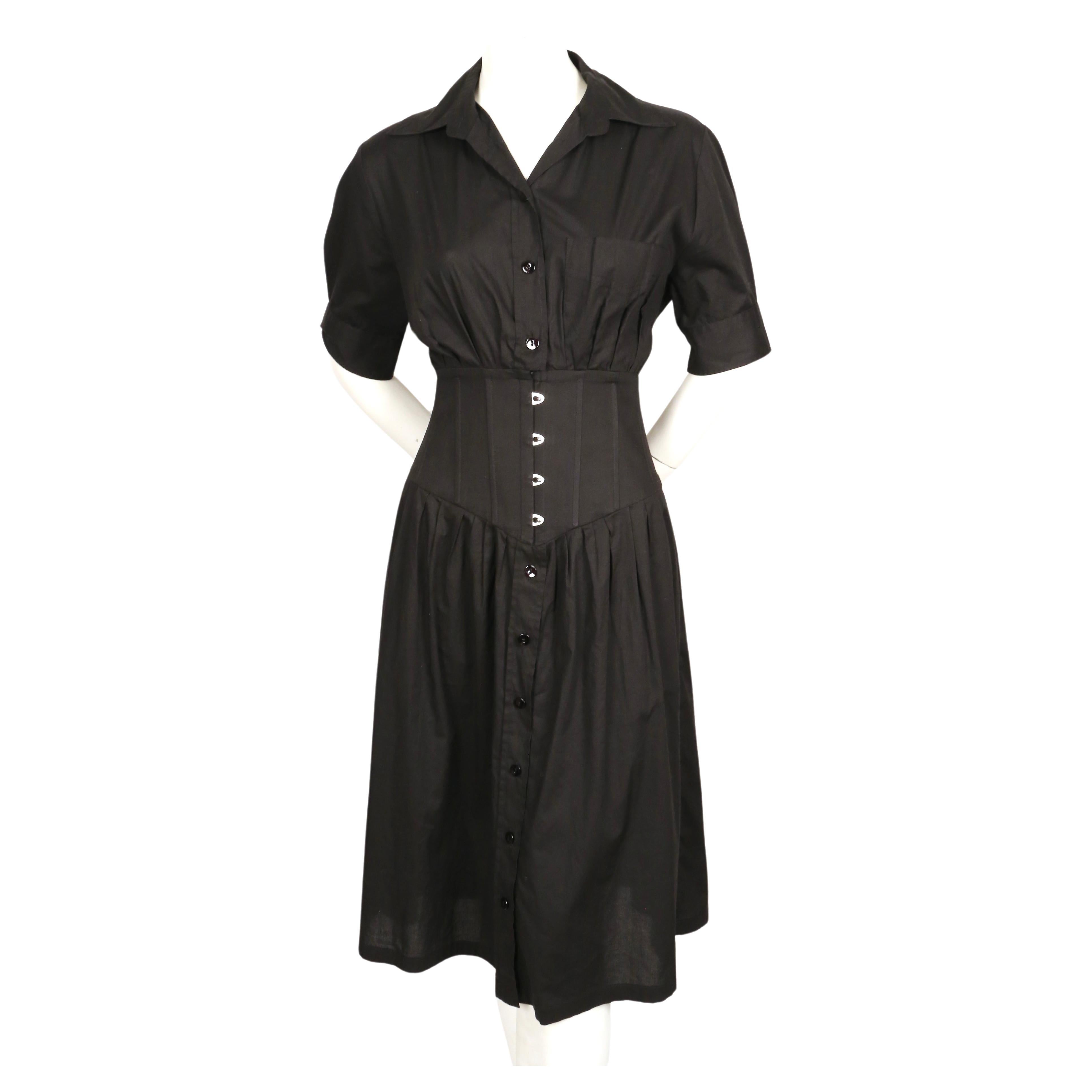 Black shirt style dress with corseted waist designed by Jean Paul Gaultier dating to the early 2000's. Labeled a French size 40 (Italian 44). Approximate measurements: shoulder 15.5