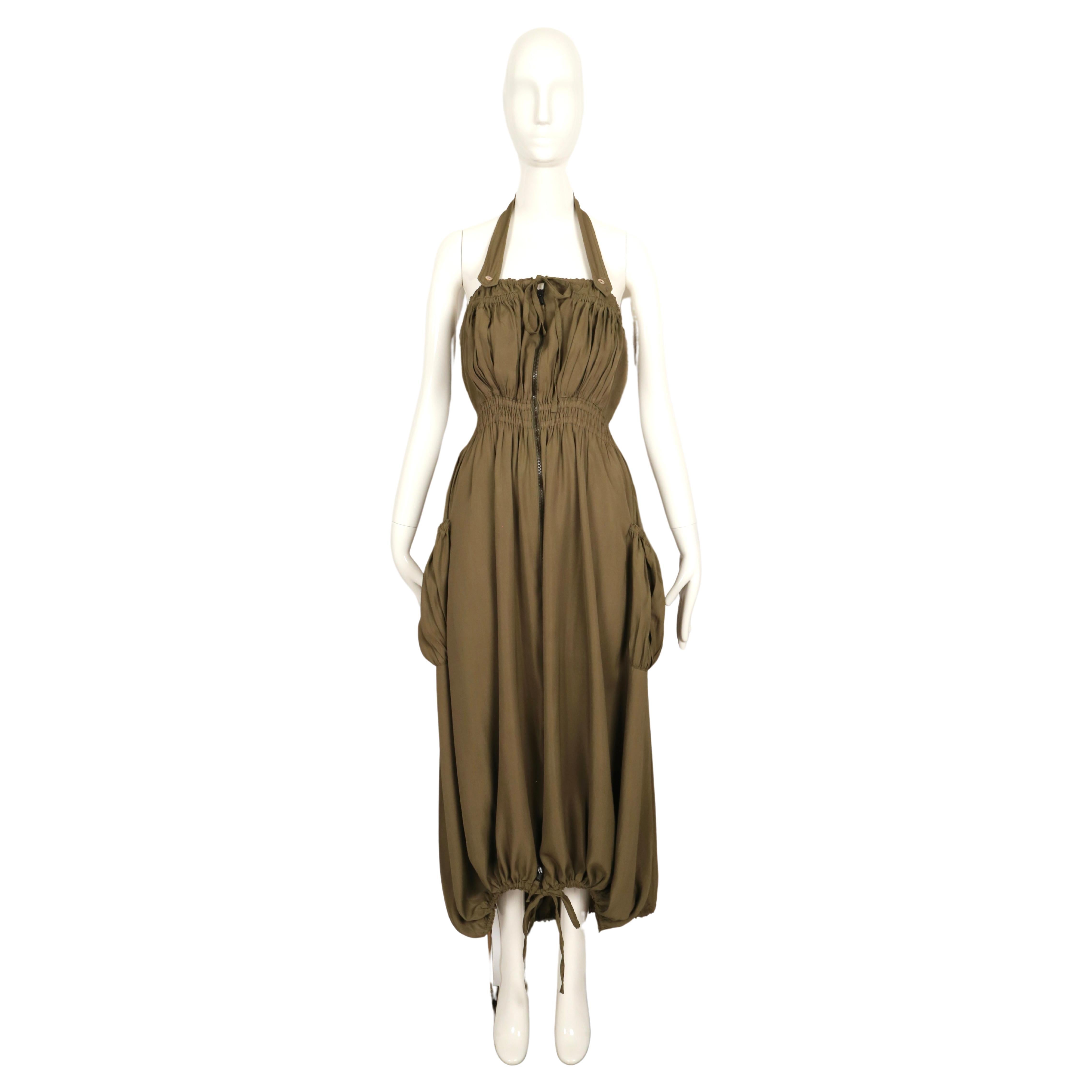 Rarísimo vestido de paracaídas caqui con bolsillos fruncidos y cordones ajustables diseñado por Jean Paul Gaultier que data de finales de la década de 1990. Etiquetada como talla 38 francesa. Las medidas son muy difíciles de tomar debido a la