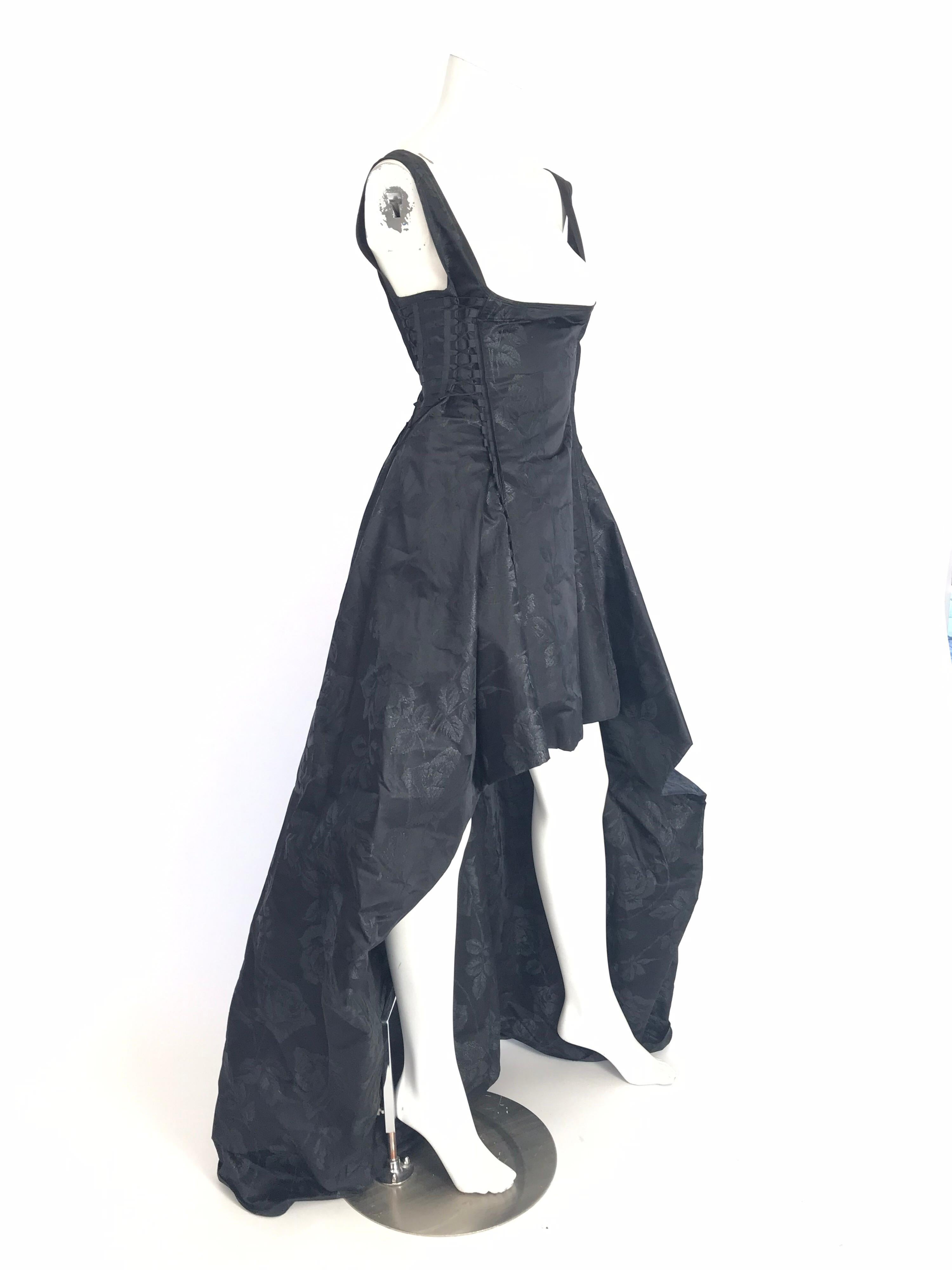 Jean Paul Gaultier black brocade evening dress with floral pattern throughout, lacing at sides, high-low hem and zip closure at back.  Silk blend. Condition: Excellent

Bust: 28