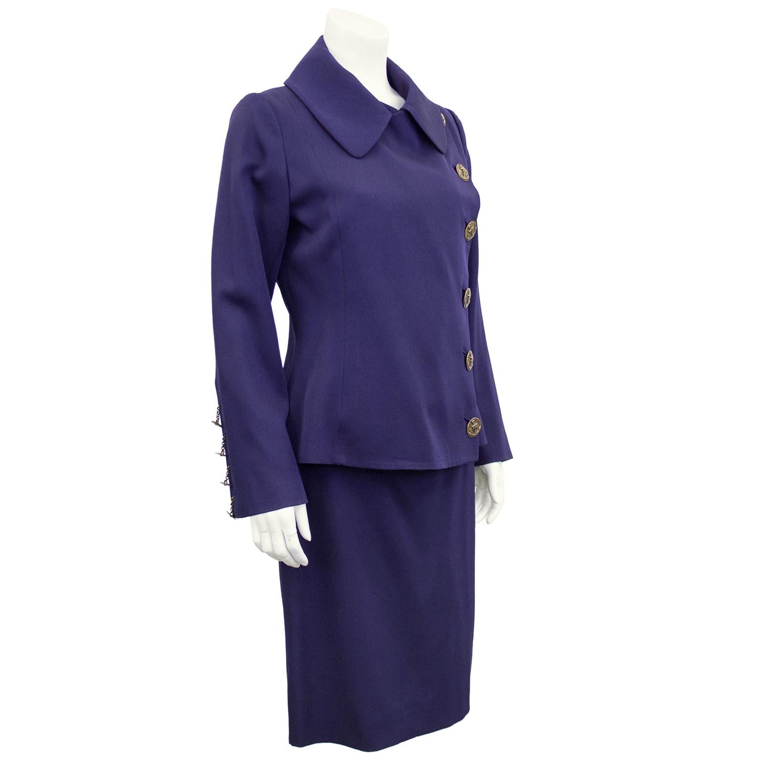 1990s Jean Paul Gaultier Femme deep dusty purple skirt suit. Jacket features an exaggerated rounded edge shirt  collar and six large distressed brass buttons with anchor and chain details hanging through brass grommets. Four smaller matching buttons