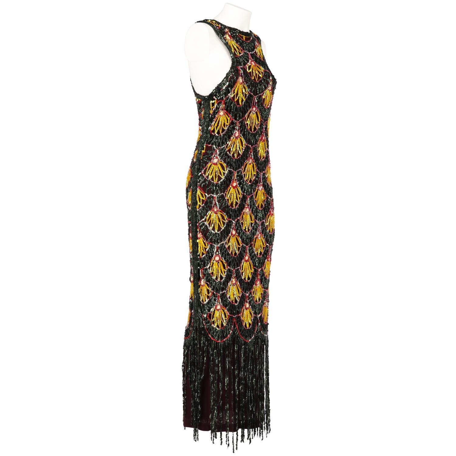 Eye-catching Jean Paul Gaultier sleeveless aubergine purple silk long dress embellished with multicolor shiny sequins. It features a round neck, cut-out lace effect and black sequins fringes at the bottom. The item is vintage, it was produced in the