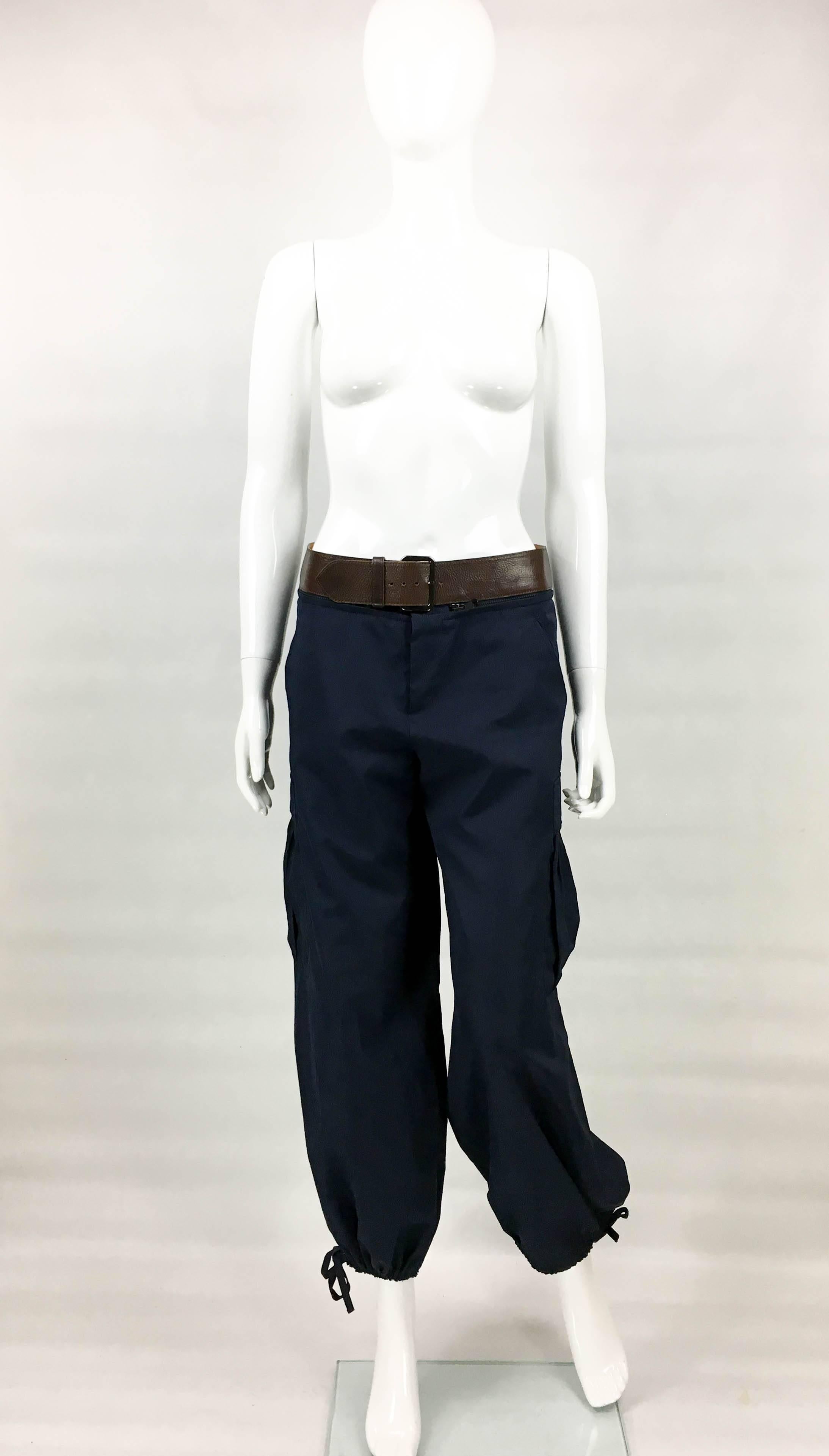 Vintage Jean Paul Gaultier Navy Blue Nylon Cargo Pants. This really cool piece by Jean Paul Gaultier dates back from the 1990’s. Made in navy blue nylon, the pants feature a detachable brown belt. With drawstrings to cuffs, they have sash pockets to