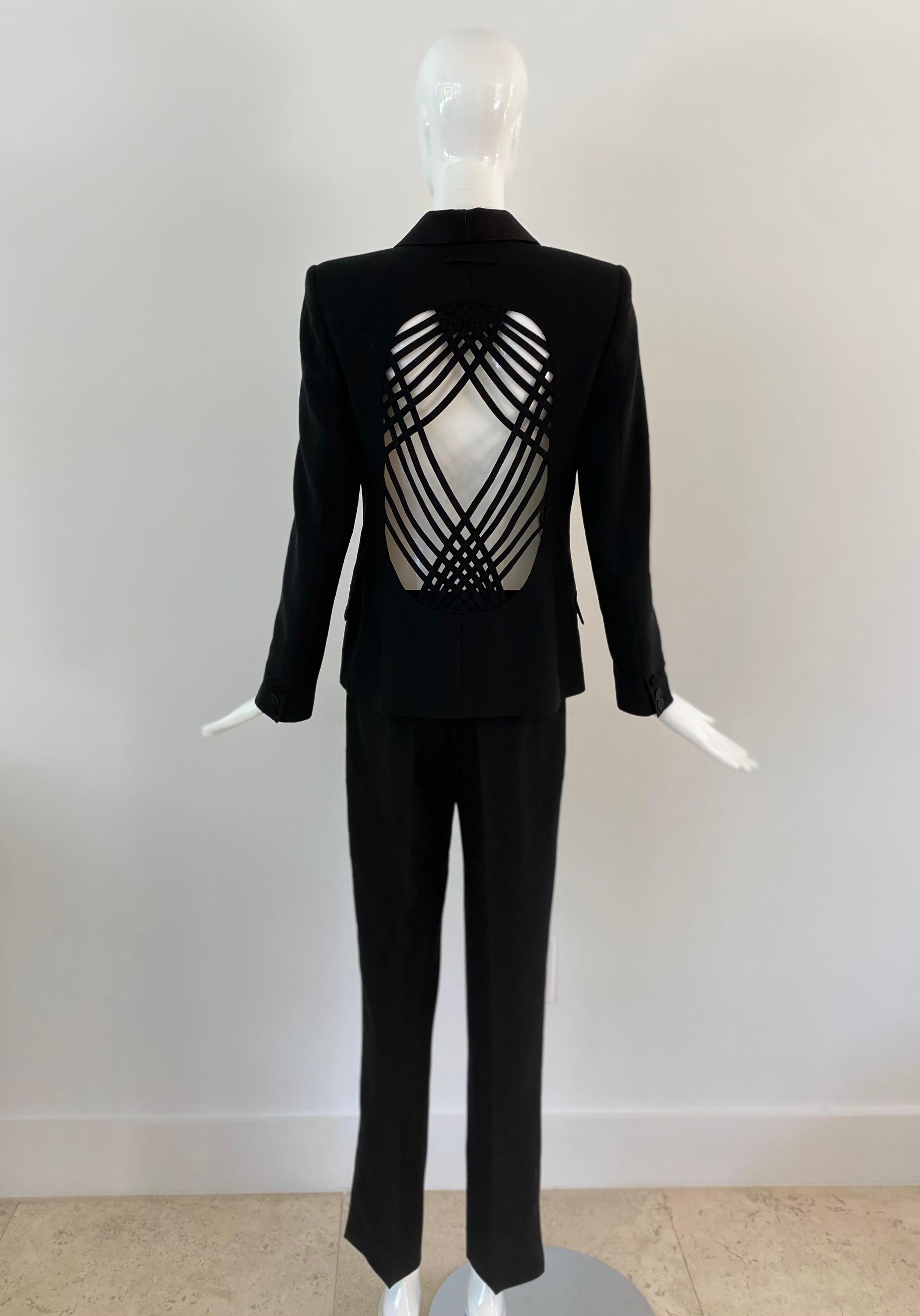 1990s Epic Jean Paul Gaultier Femme tuxedo black suit. The jacket is marked as a European size 42 and the pant as a European size 40. They are both made from virgin wool and rayon. The pant has a black satin tuxedo line on both sides. The jacket has