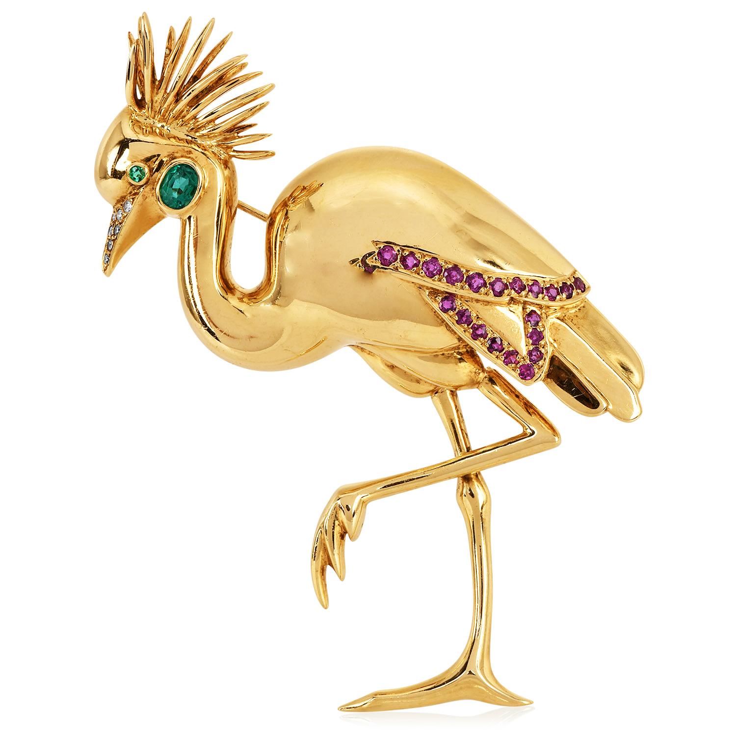 Cette superbe épingle à flamant rose originale de Jean Vitau datant de 1990 est réalisée en or jaune massif 18 carats. Cette épingle est ornée de pierres précieuses et de diamants de haute qualité.  Deux émeraudes sur l'œil et la tête pesant environ