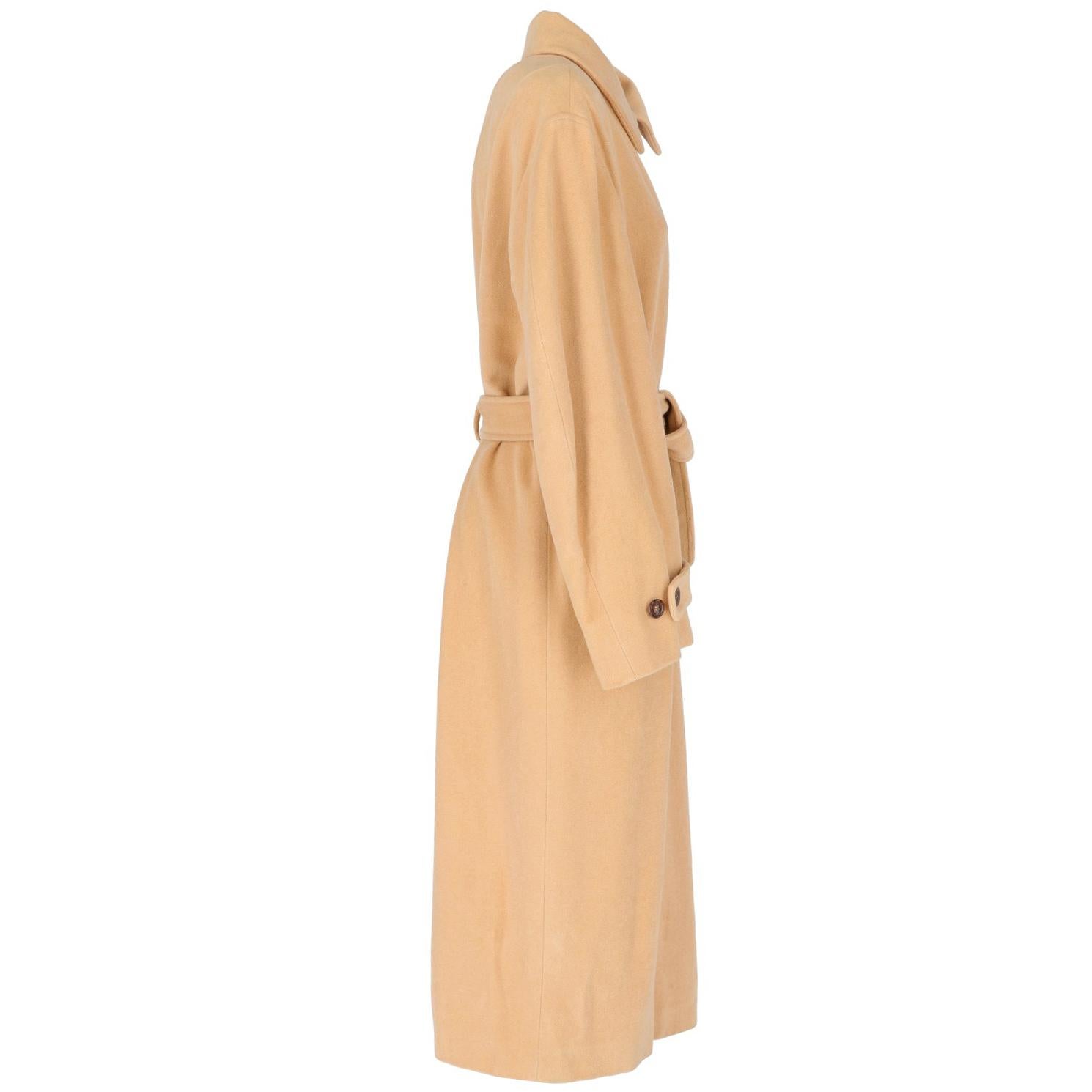 The Jil Sander long beige wool coat features a classic collar, a fly front closing, a waist belt with covered brown leather buckle, a thread chest pocket and two side pockets, an adjustable cuffs througth buttons and a 53 cm back slit. Lined.

A