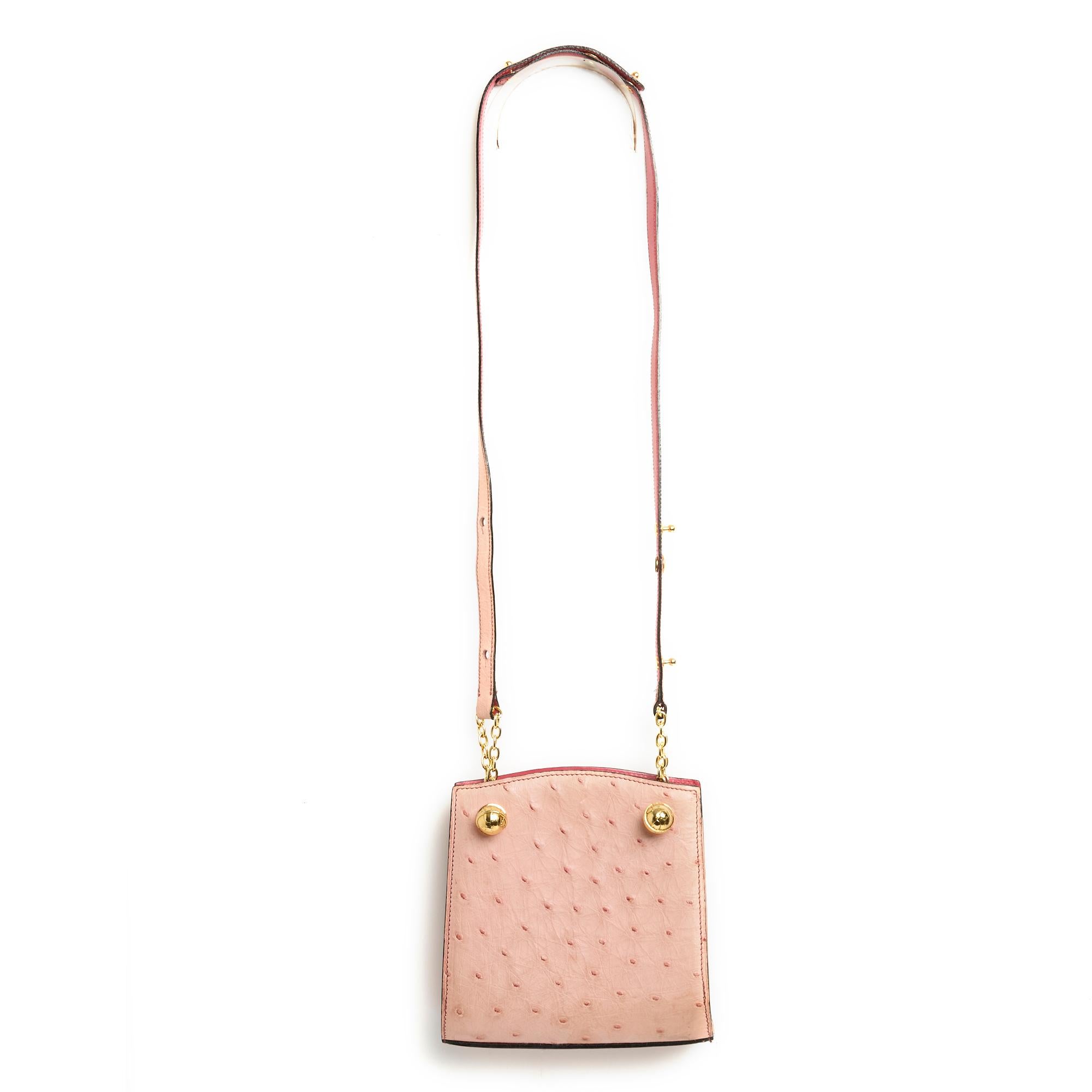 Small Jean-Claude Jitrois bag in pale pink ostrich leather, interior in bright pink leather with 2 compartments separated by a zipped pocket, shoulder strap to be worn short or long for shoulder or cross body wear held in place by 2 metal 