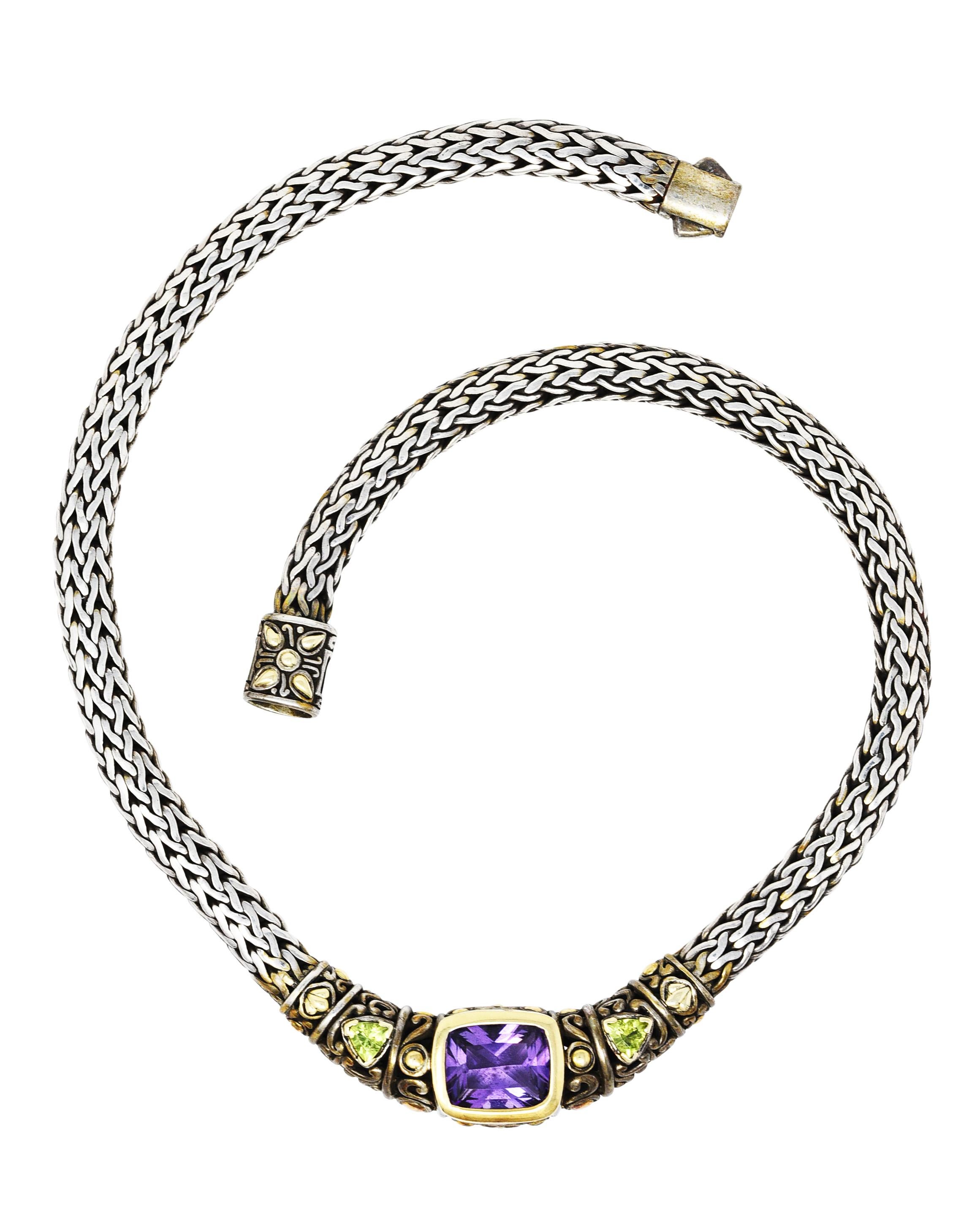 Collar necklace comprised of wheat chain featuring a center station

Centering cushion cut amethyst measuring approximately 13.2 x 11.0 mm

Medium light in saturation - pinkish purple in color and bezel set in gold

Flanked by two trillion cut