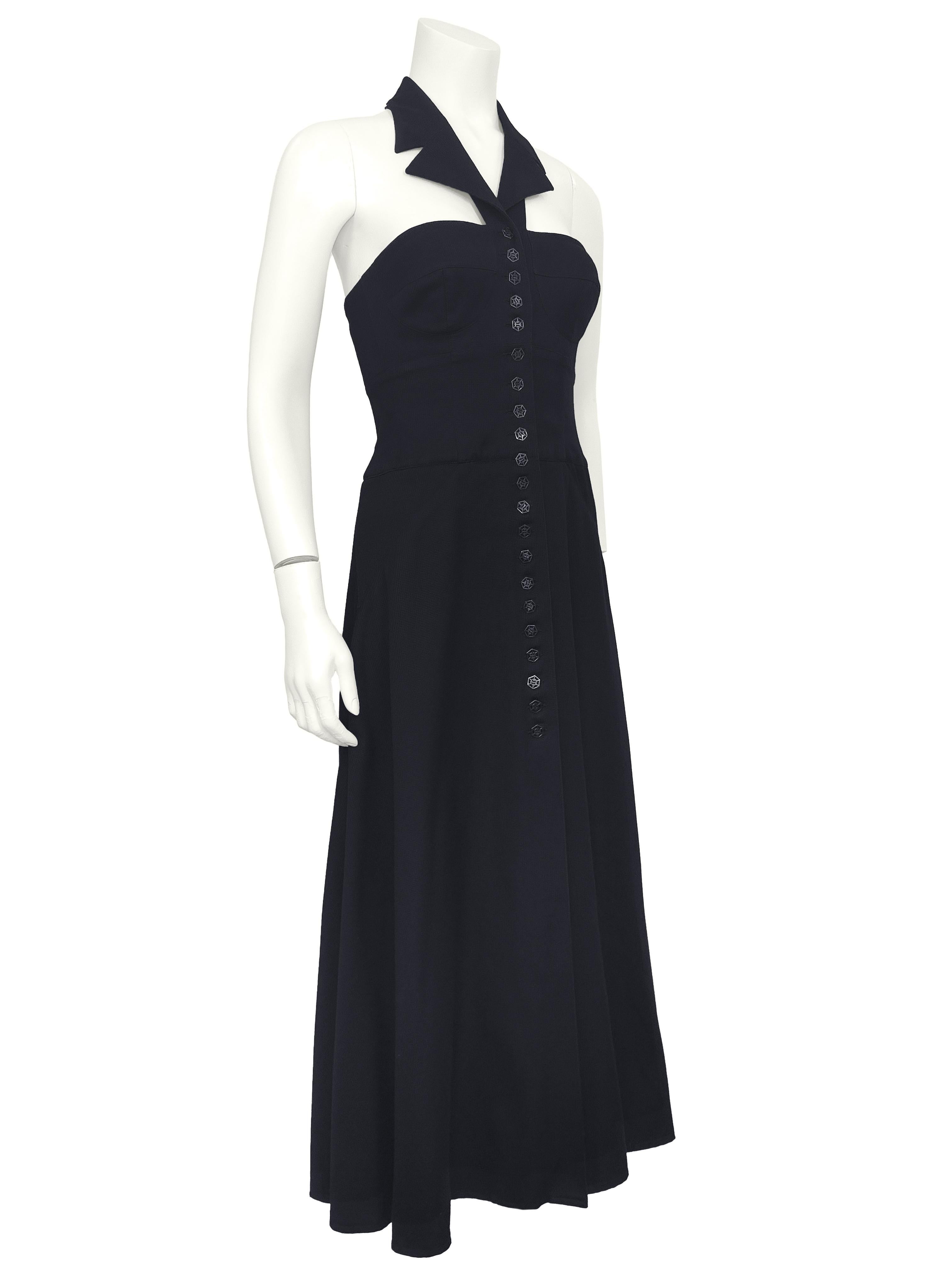 Cette robe Karl Lagerfeld des années 1990 est un mélange de tailleurs pointus et d'allure féminine, caractéristique du créateur. En tissu piqué de coton noir au drapé impeccable, la robe présente une encolure dos nu avec un col cranté et un dos