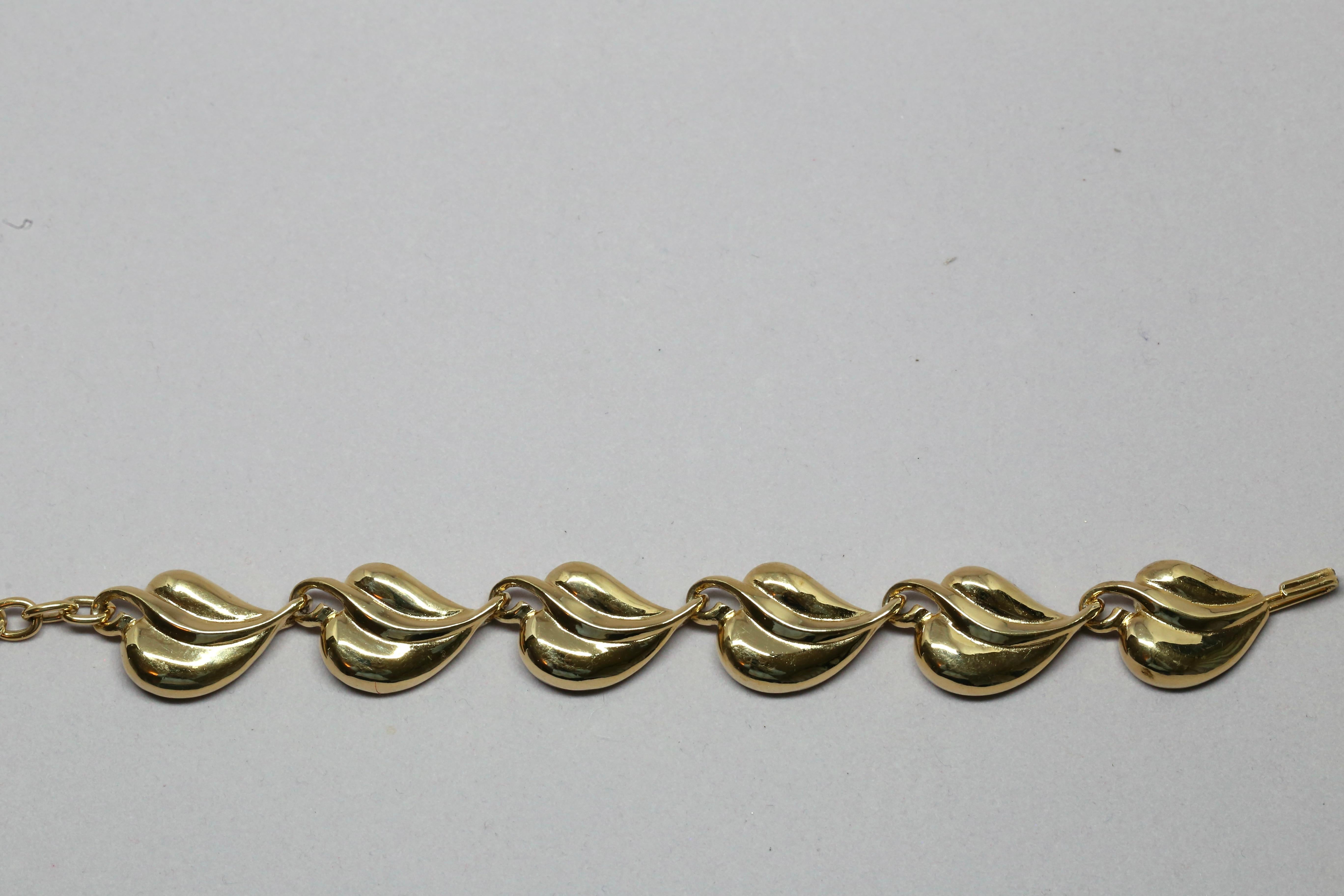 Shiny, leaf-shaped link bracelet from Karl Lagerfeld dating to the 1990's. Approximate measurement: .75