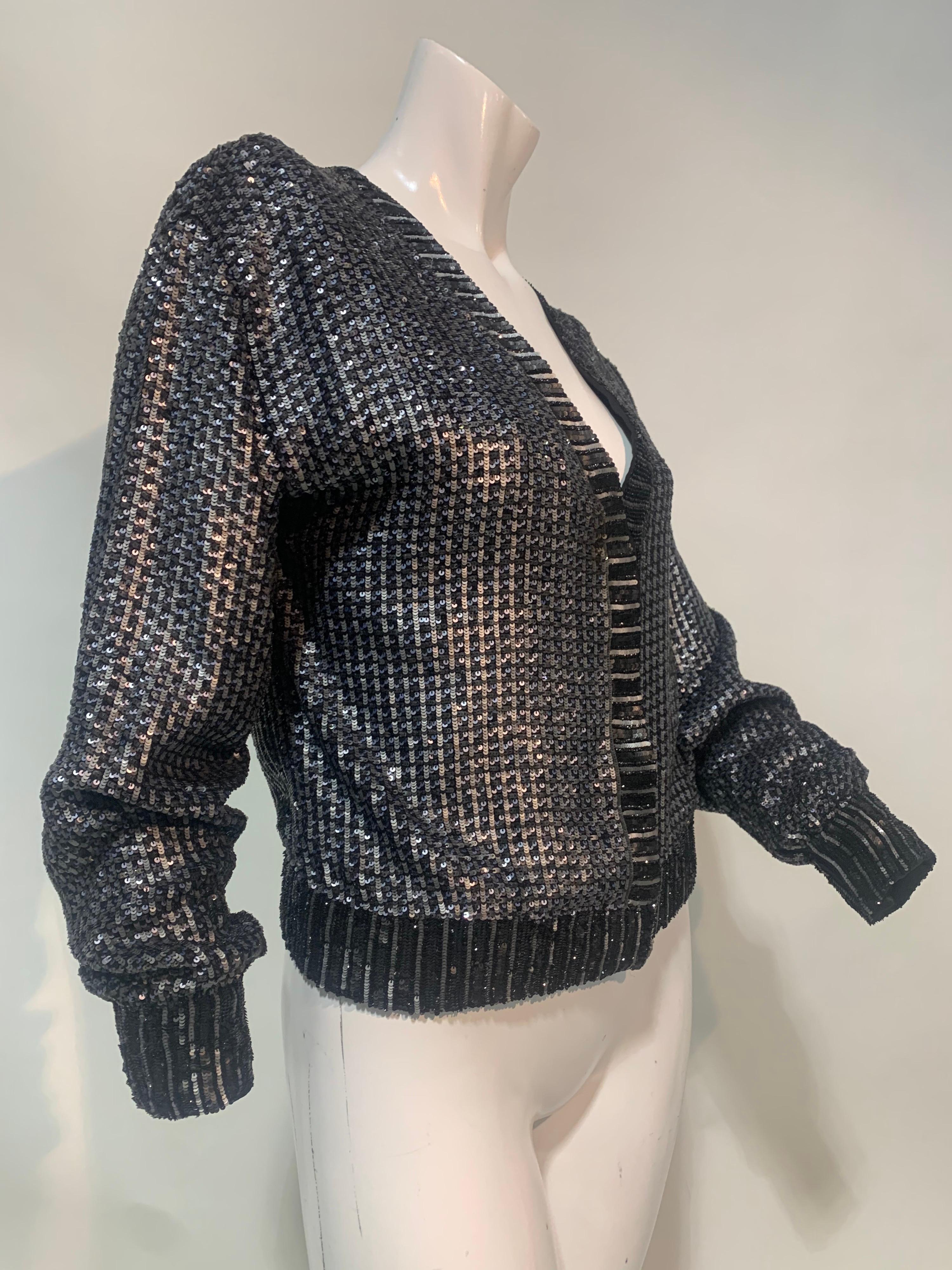 A slinky 1990s Karl Lagerfeld gray silk mesh cardigan-style jacket covered completely in small gunmetal sequins. Front snap closures. Sequin configuration gives a ribbed effect at hem and edgings. Size EU 42.