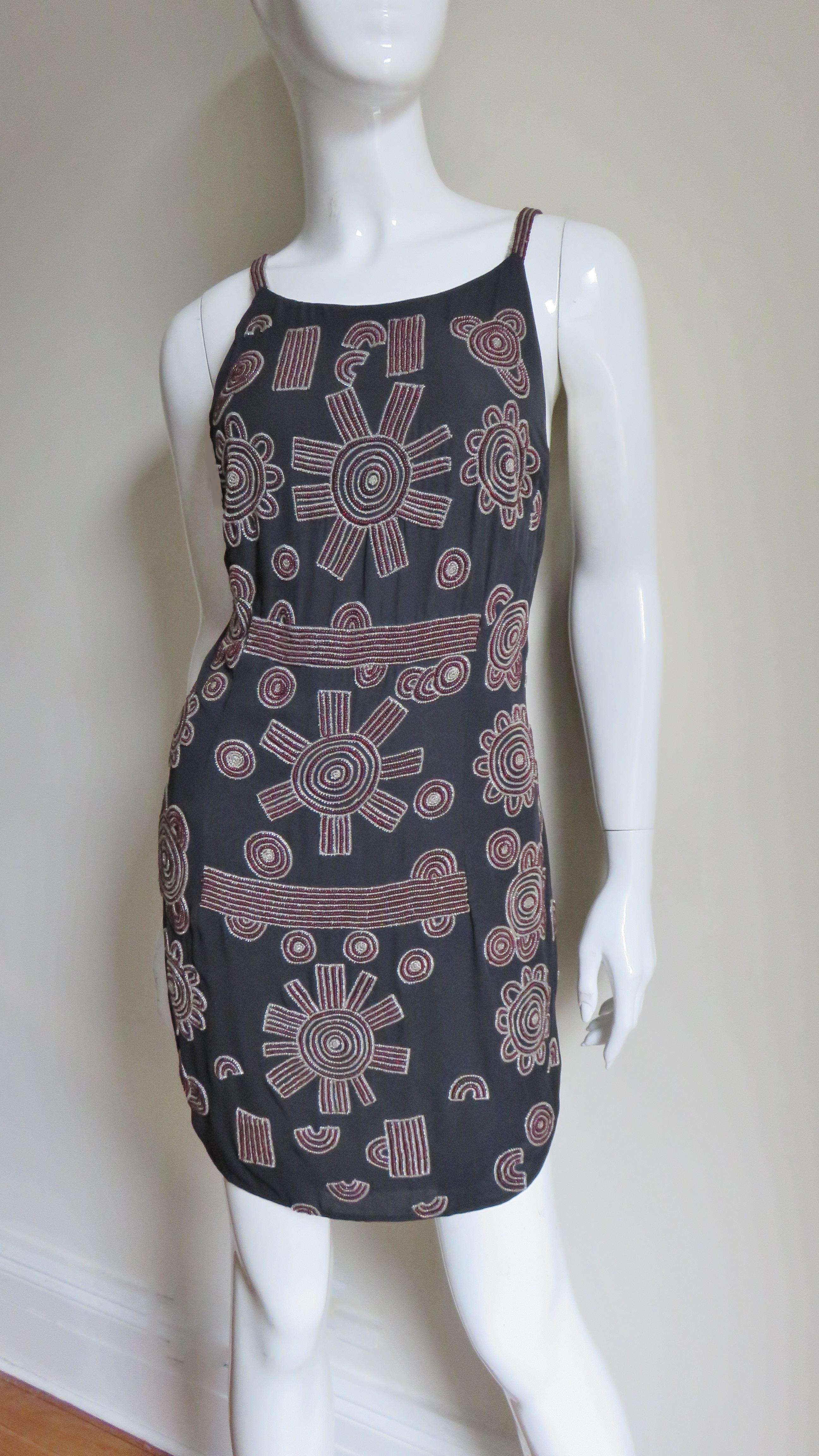 A gorgeous navy silk dress with beautifully beaded circles and lines in clear and burgundy glass beads from Karl Lagerfeld.  It skims the body and has small shoulder straps, a low back with a zipper and is fully lined in the same navy silk.