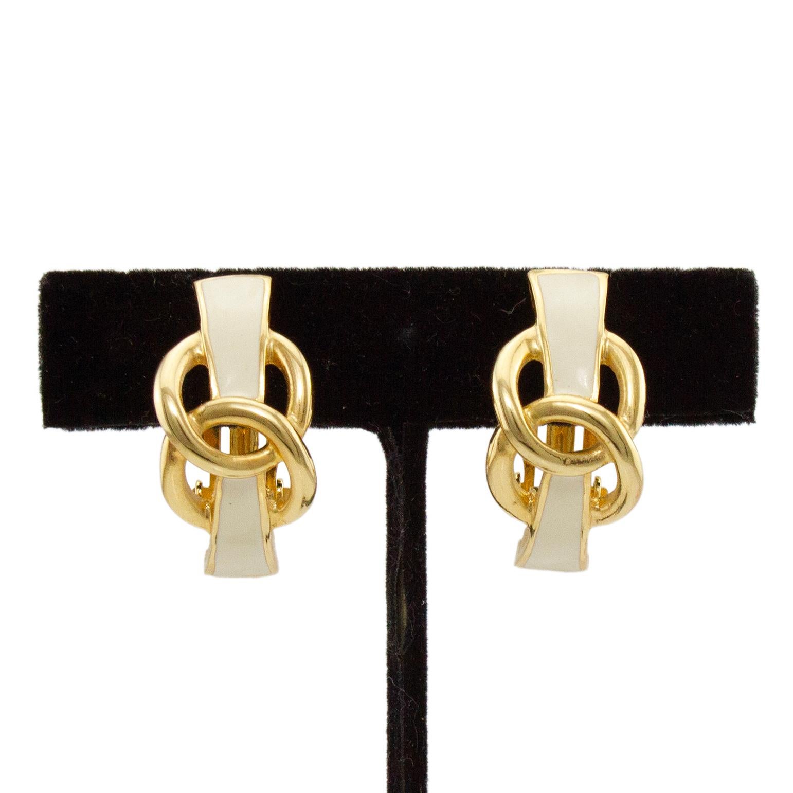 Kenneth Jay Lane cream and gold enamel clip on earrings with a twisted circle detail. In excellent condition, normal signs of wear throughout. Circa 1990s.

1