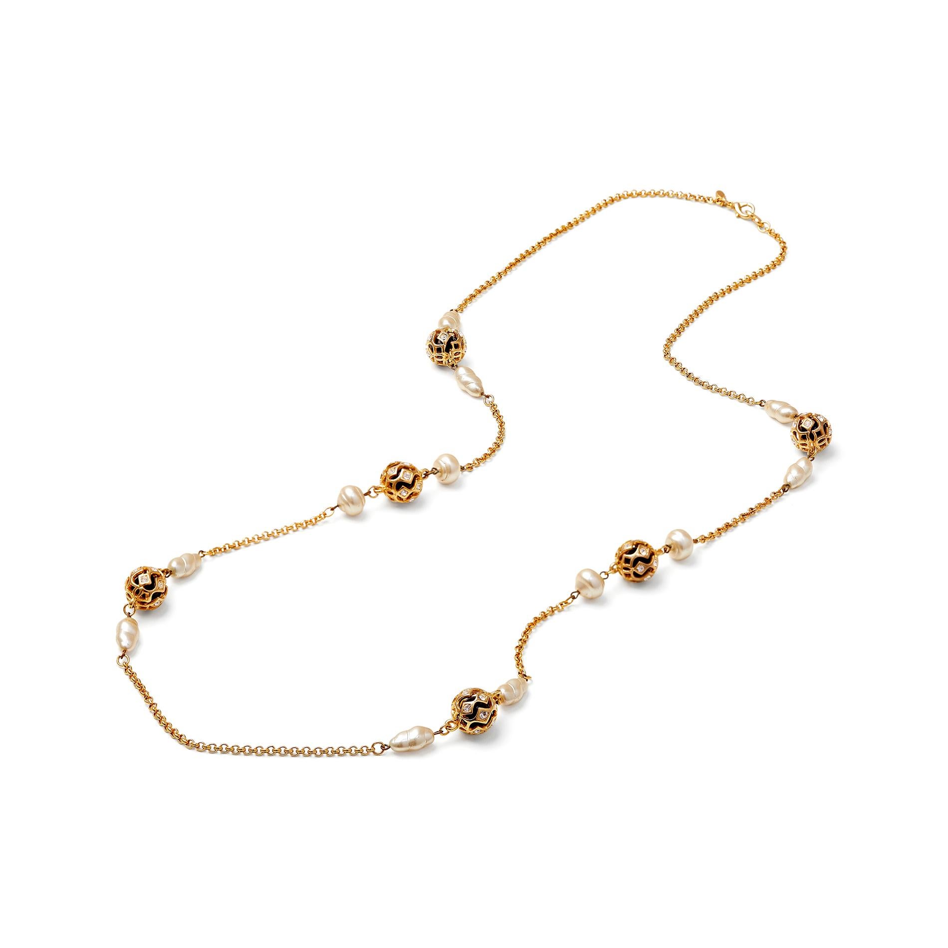 This vintage early 1990s Kenneth Jay Lane necklace features a repeat of bead clusters on a long gold coloured chain, finished with a sturdy clasp and the 'Kenneth Lane' cartouche.  Each cluster is made up of two imitation pearls, each flanking a