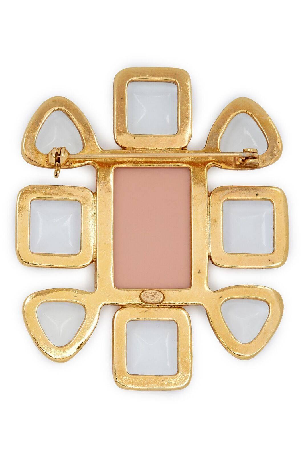 Gold-tone Chanel brooch featuring clear glass (gripoix) cabochons, rose enamel centrepiece with a small double CC affixed to the centre. C clasp pin closure. From the Spring 1996 Collection. 

In excellent vintage condition.

2 1/4 inches/6.5cm wide