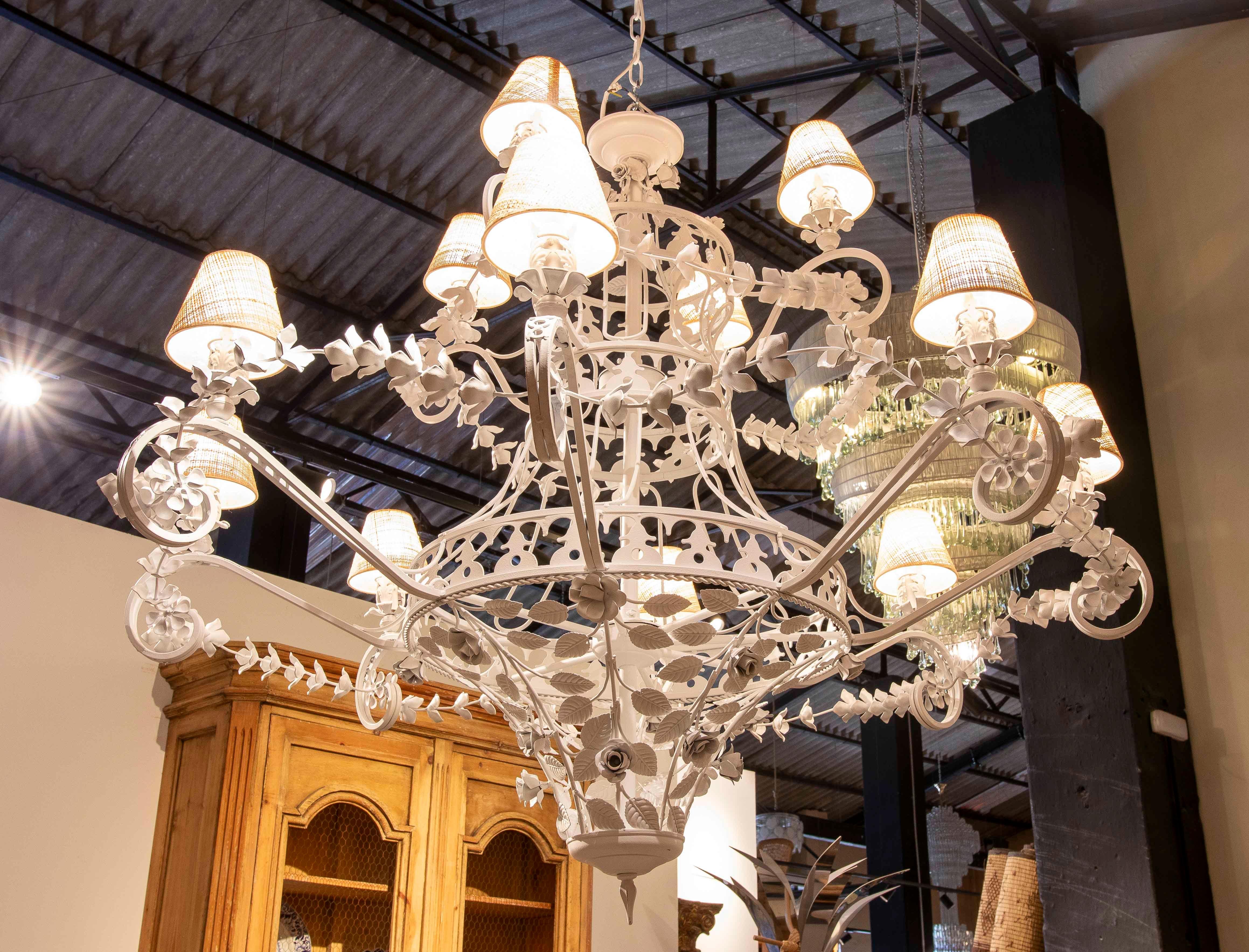 Spectacular oversized pendant light crafted from wrought iron and painted matte white. Its majestic crown design incorporates floral details and intertwined branches, giving it a romantic, handcrafted feel. Equipped with multiple arms supporting