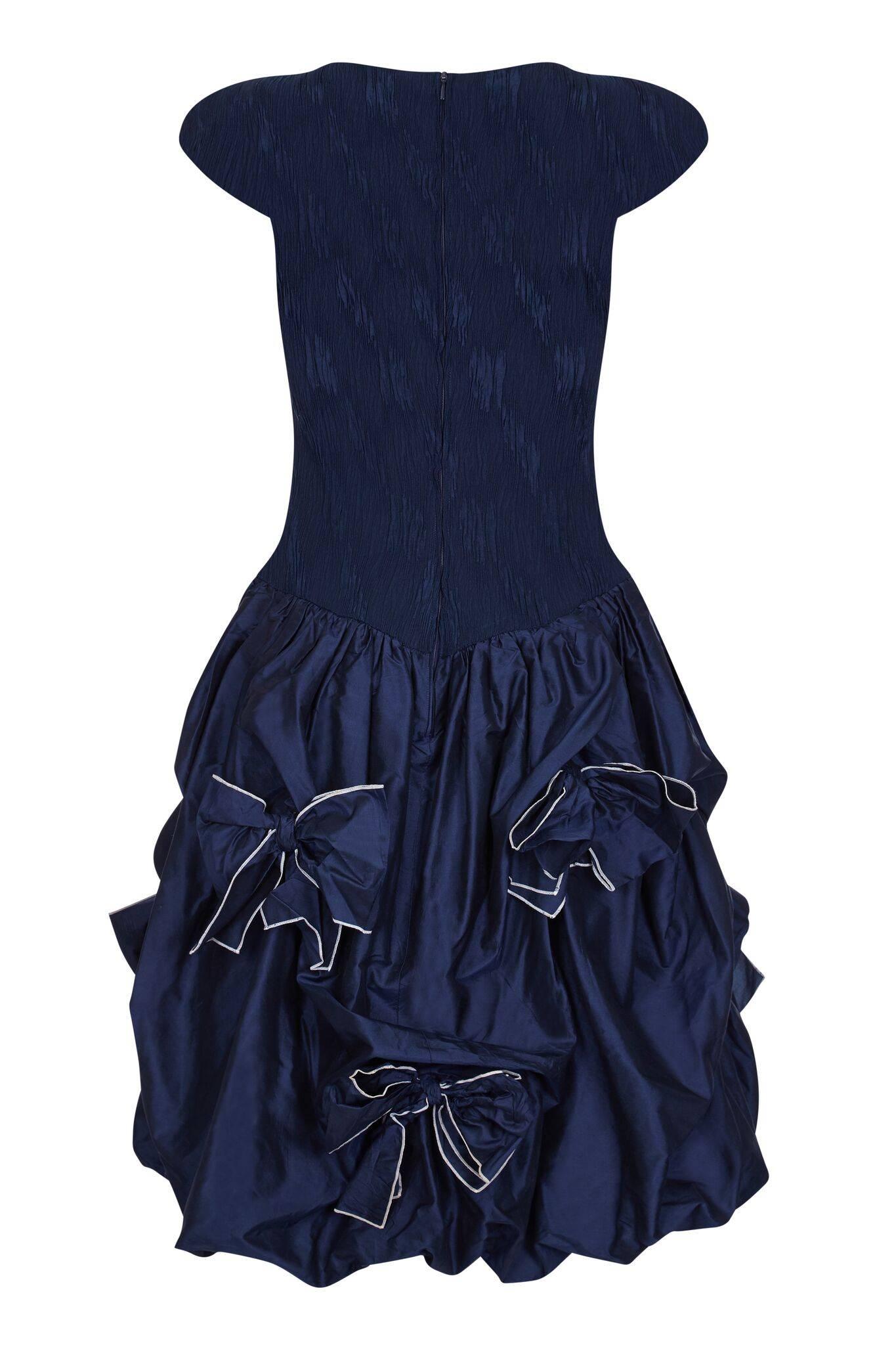 This lovely Louis Feraud late 1980s or early 1990s navy party dress in silk taffeta is both stylish and playful in its aesthetic. The simple bodice of stretched silk blend crepe adheres effortlessly to the contours of the wearer. The bodice with its