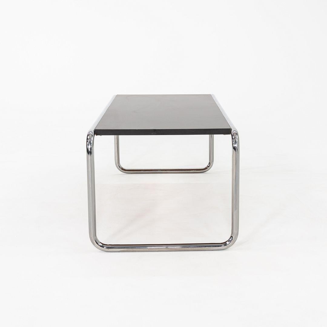 This is a Laccio Coffee Table, originally designed by Marcel Breuer in 1925. This particular example was produced by Thonet in the United States and dates to the 1990s. The table features a tubular steel frame with a black laminate table top.