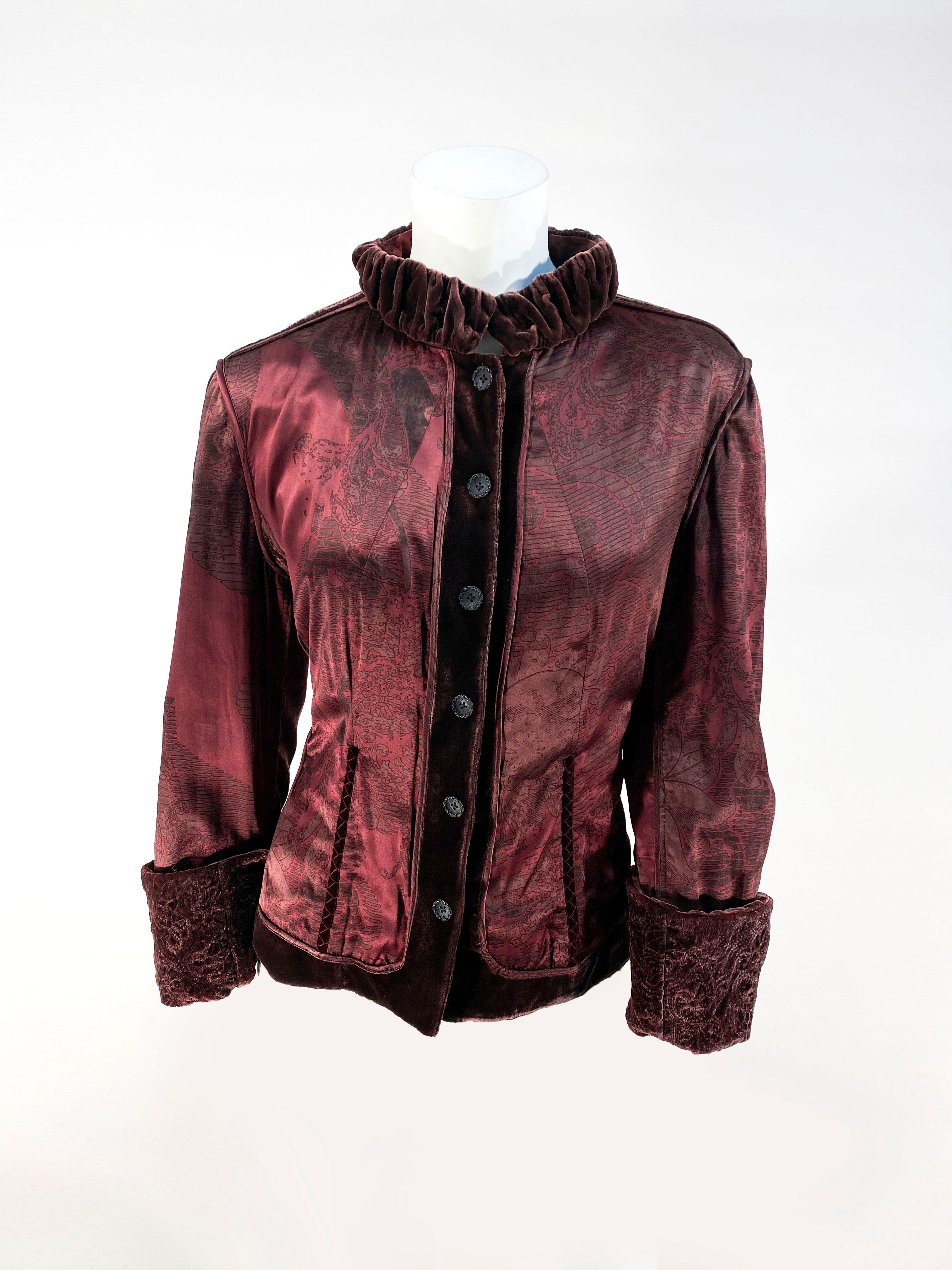 1990s maroon reversible jacket with cocoa brown velvet, patch pockets, decorative buttons, and silk covered snaps. On the reversible side, is a paisley printed silk shell with ruched collar, and velvet cuffs. The back is decorated with stays/boning