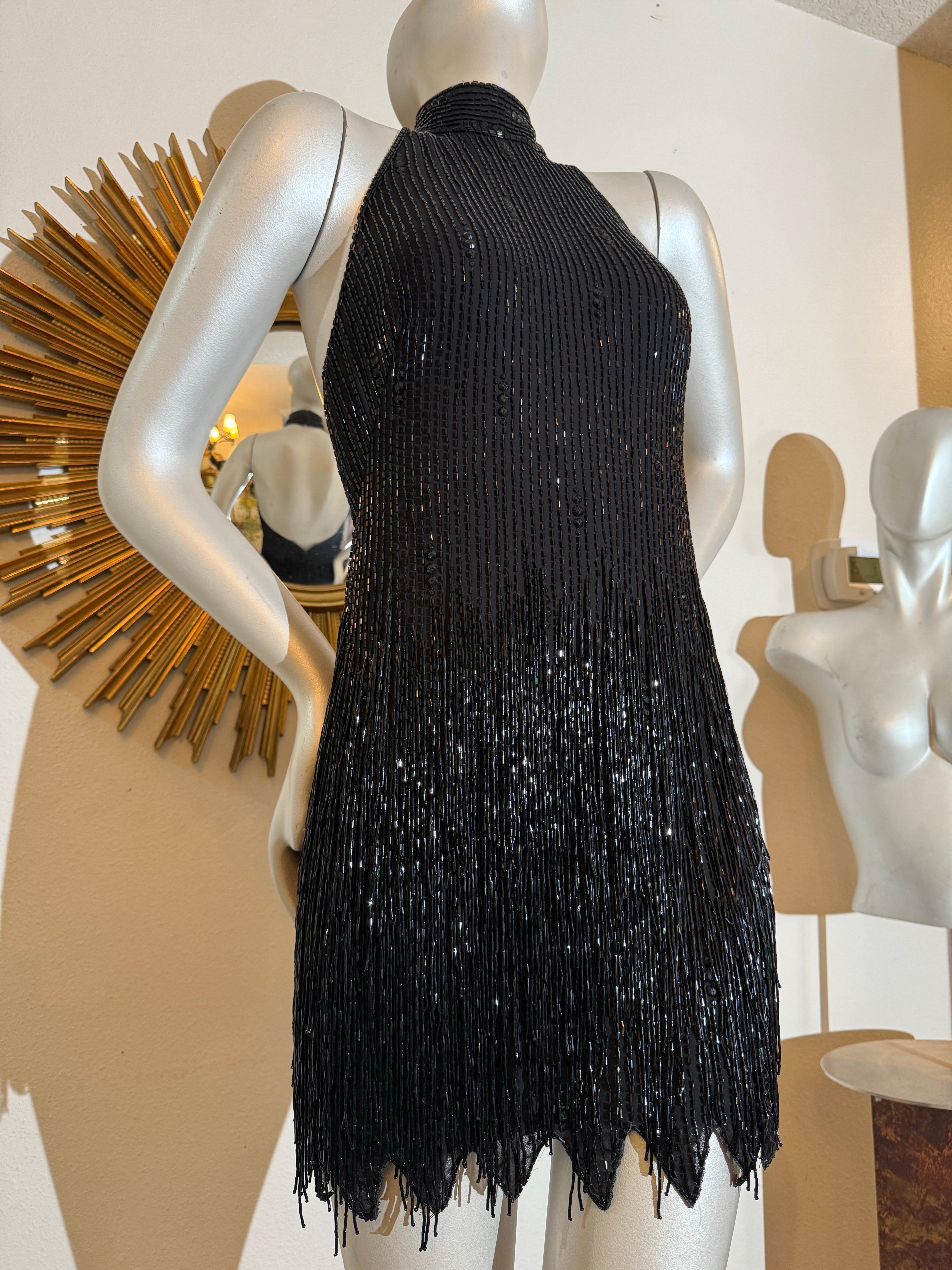 Michael Casey, años 90, mini vestido halter negro con abalorios y cristales y flecos:  Una fabulosa pieza de muestra única del archivo privado de Michael Casey en Nueva York.  Una pieza perfecta de muestra de la talla 6, con el estilo clásico de