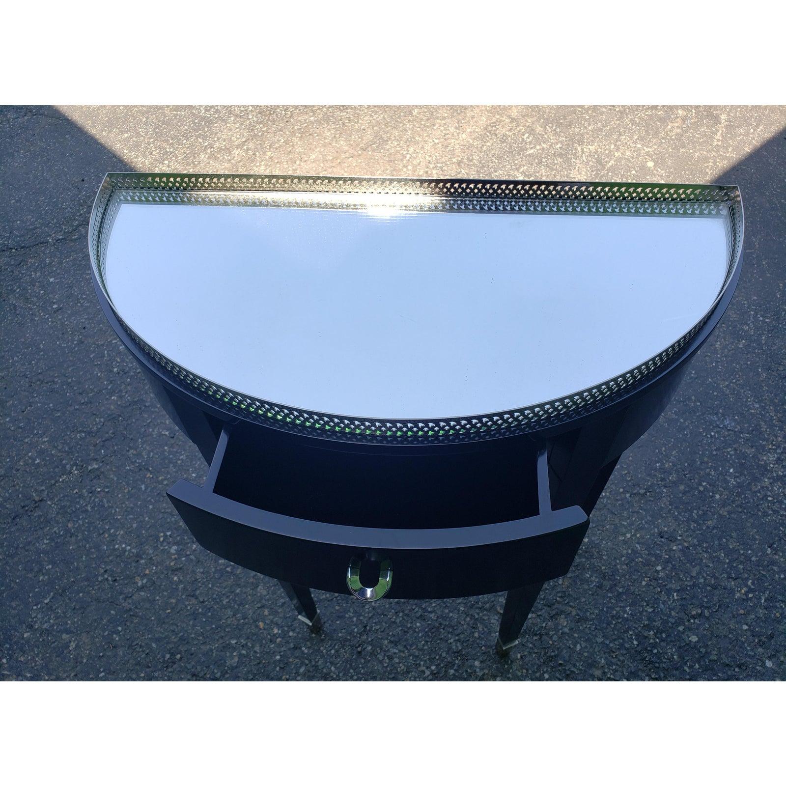 Contemporary foyer table with mirrored top. Mirror is removable. Maker unknown.
Beautiful ornate top edge with silver gallery and one front center drawer and silver metallic capped legs. Absolutely beautiful for any entrance or hall.
Measures: 24W