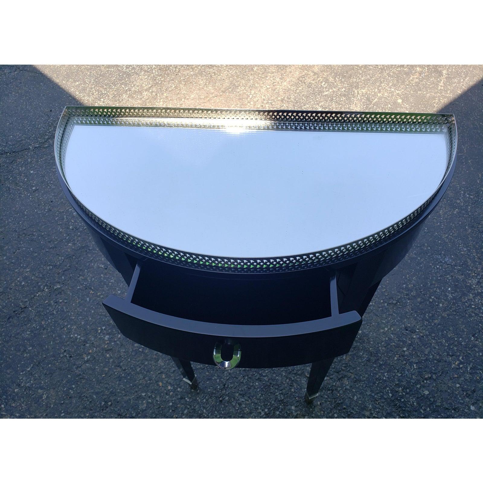 Table d'entrée contemporaine avec plateau en miroir. Le miroir est amovible. Fabricant inconnu.
Magnifique bord supérieur orné d'une galerie argentée, d'un tiroir central à l'avant et de pieds coiffés de métal argenté. Absolument magnifique pour