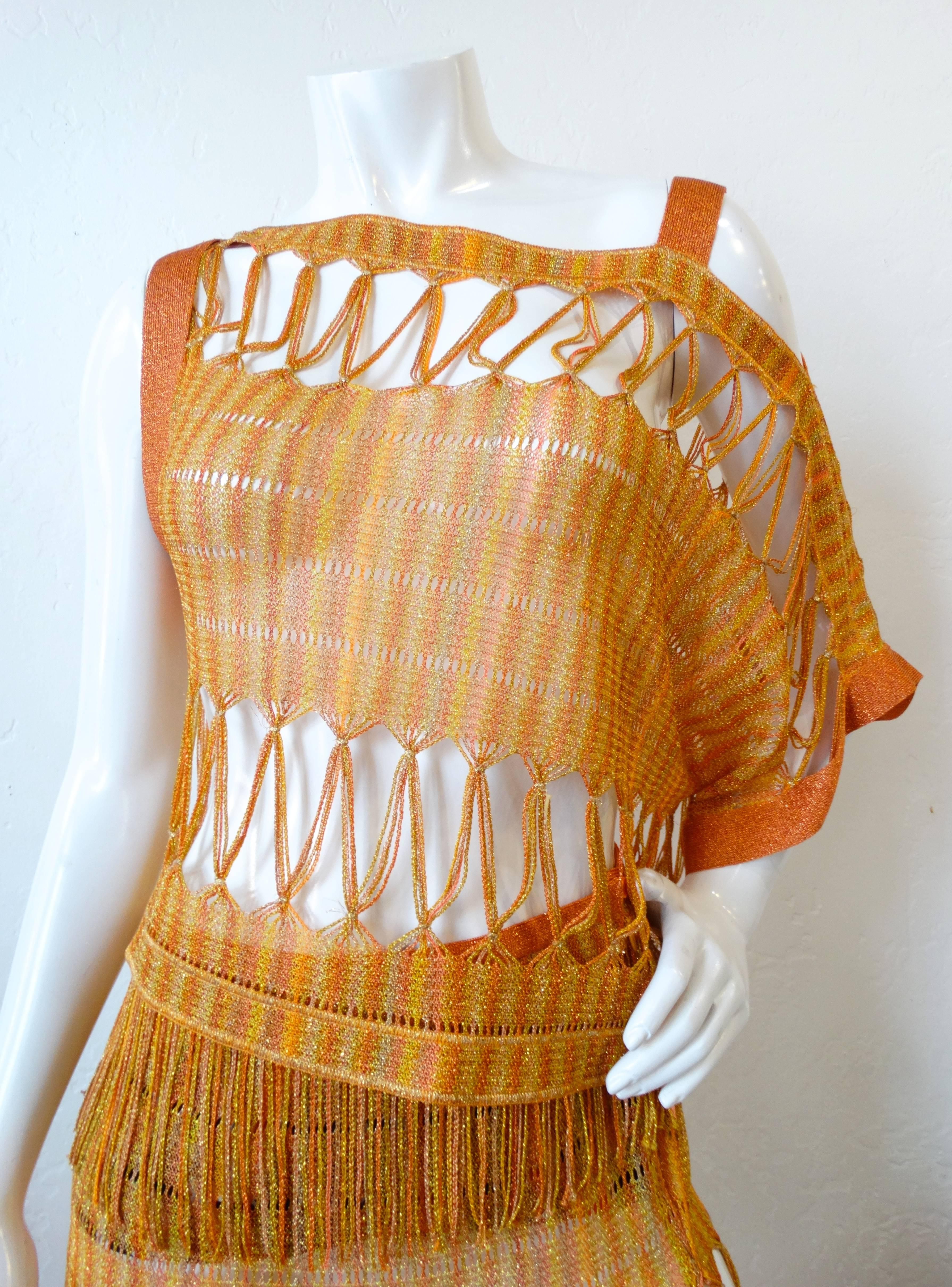 The PERFECT Missoni set for festival season- down to the fringe! Open weave knit made of metallic orange and yellow thread. Top has a unique silhouette, sleeveless on one side and strappy on the other. Looks incredible worn over a swim suit. Skirt