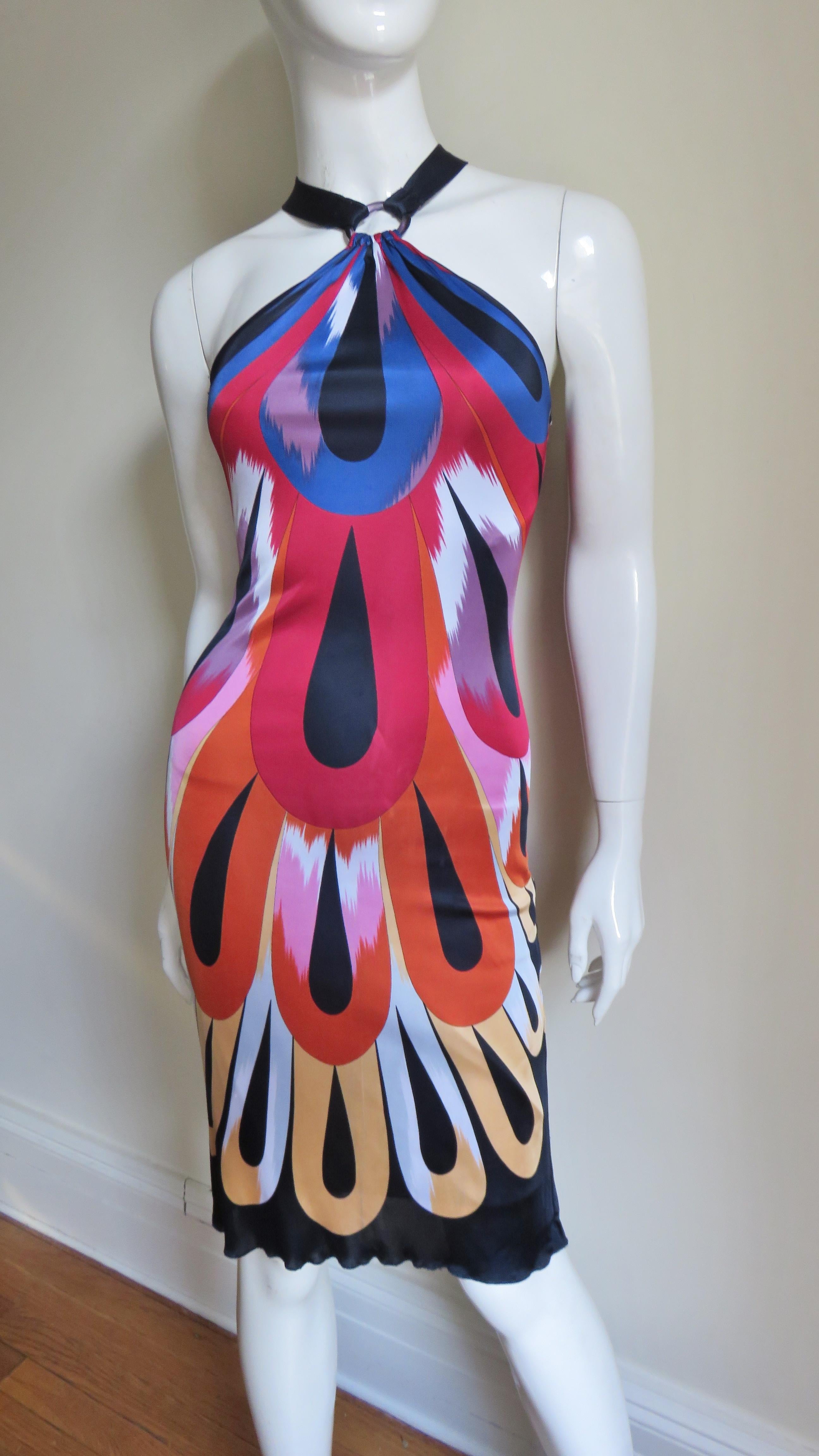 A fabulous colorful fine silk knit halter dress from Missoni in a red, orange, blue, yellow, white, lavender and black abstract pattern. It slips on over the head and has 2 black straps attached to rings that go around the neck.  The dress follows