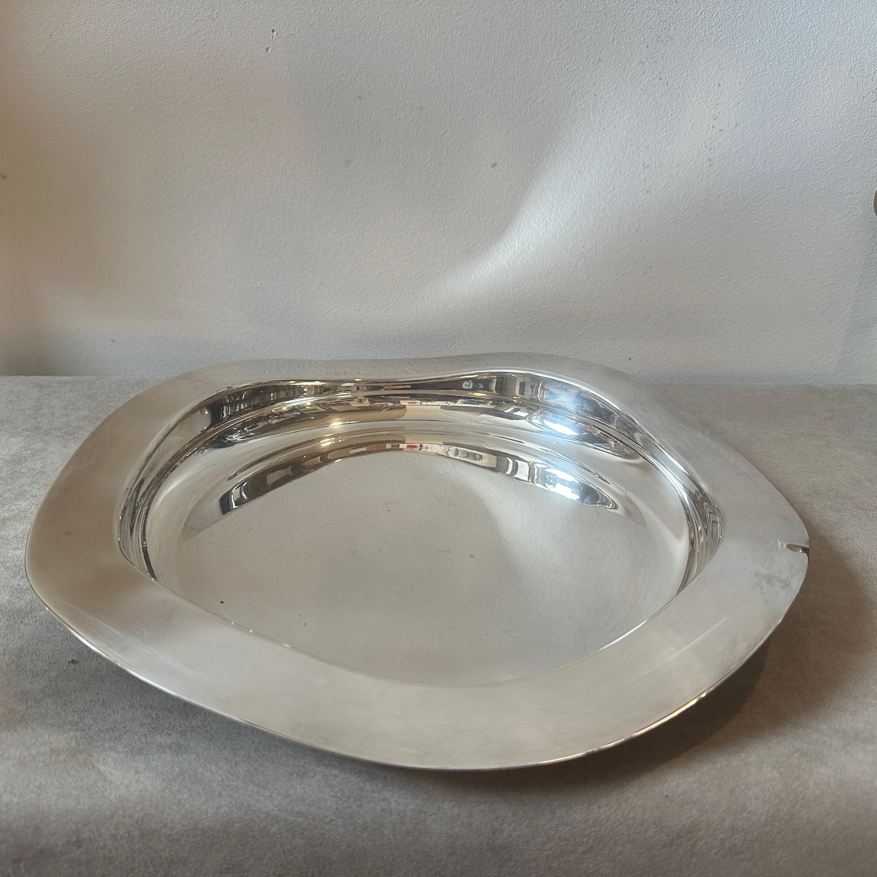 Un icónico centro de mesa redondo plateado diseñado por Francesco Bettoni y fabricado por Mesa Italia en los años noventa, está marcado en la parte inferior y en buen estado en general. 
En 1980, Giuliano Malimpensa funda Mesa. Tras trabajar con Gio