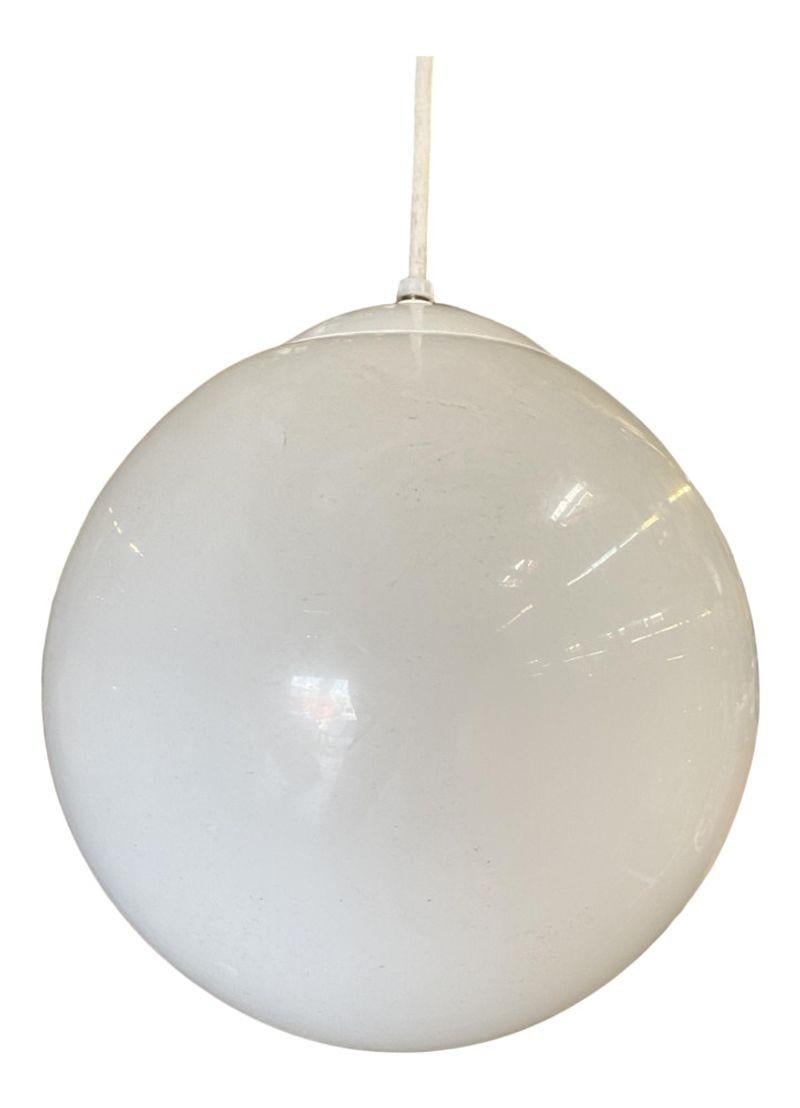 Grand luminaire à boule de verre suspendu de style MOD, à l'image de ceux que l'on trouve dans les habitations modernes de la fin des années 60 et du début des années 70. Le luminaire est composé d'une grande sphère de verre suspendue à une plaque