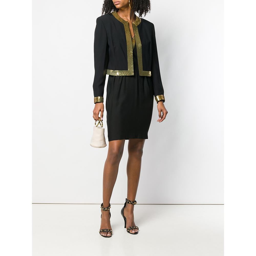 Moschino black suit with open jacket with round collar, long sleeves and hems finished with golden sequins; knee-length dress with V-neck with sequins, sleeveless, slim waist and hidden closure.

Years: 90s

Made in Italy

Size: 42 IT

Linear