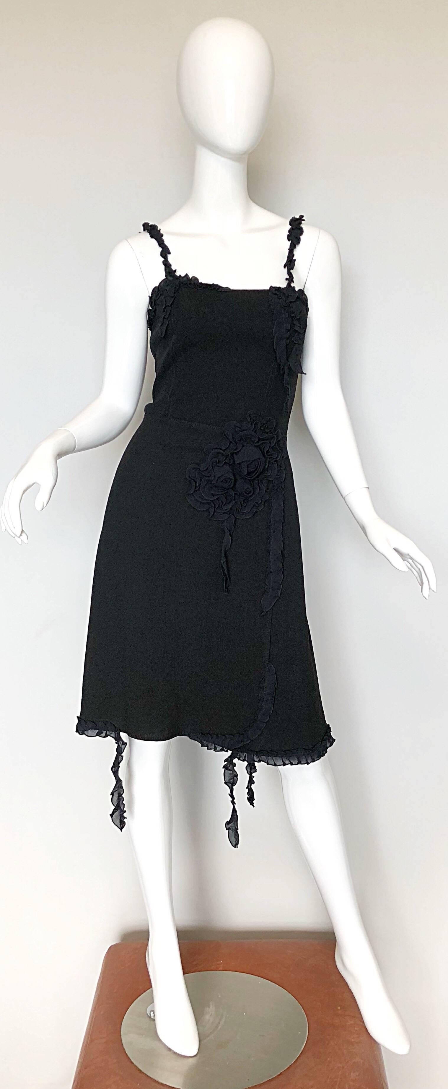 Classic, with an edge 1990s MOSCHINO CHEAP AND CHIC little black dress! Features a fitted tailored bodice with black rosettes and appliqués on left waist. Flirty skirt can accomodate an array of sizes. Fringe-like detail below each strap, and