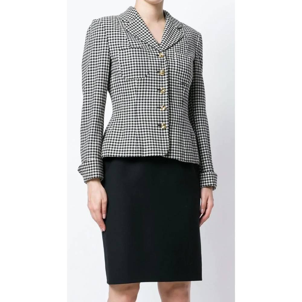 Moschino black and white wool with checked pattern suit, jacket with classic lapel collar, front closure with golden buttons, long sleeves and martingale on the back. Sleeveless dress with hidden back zip closure, square neckline with fringed hem