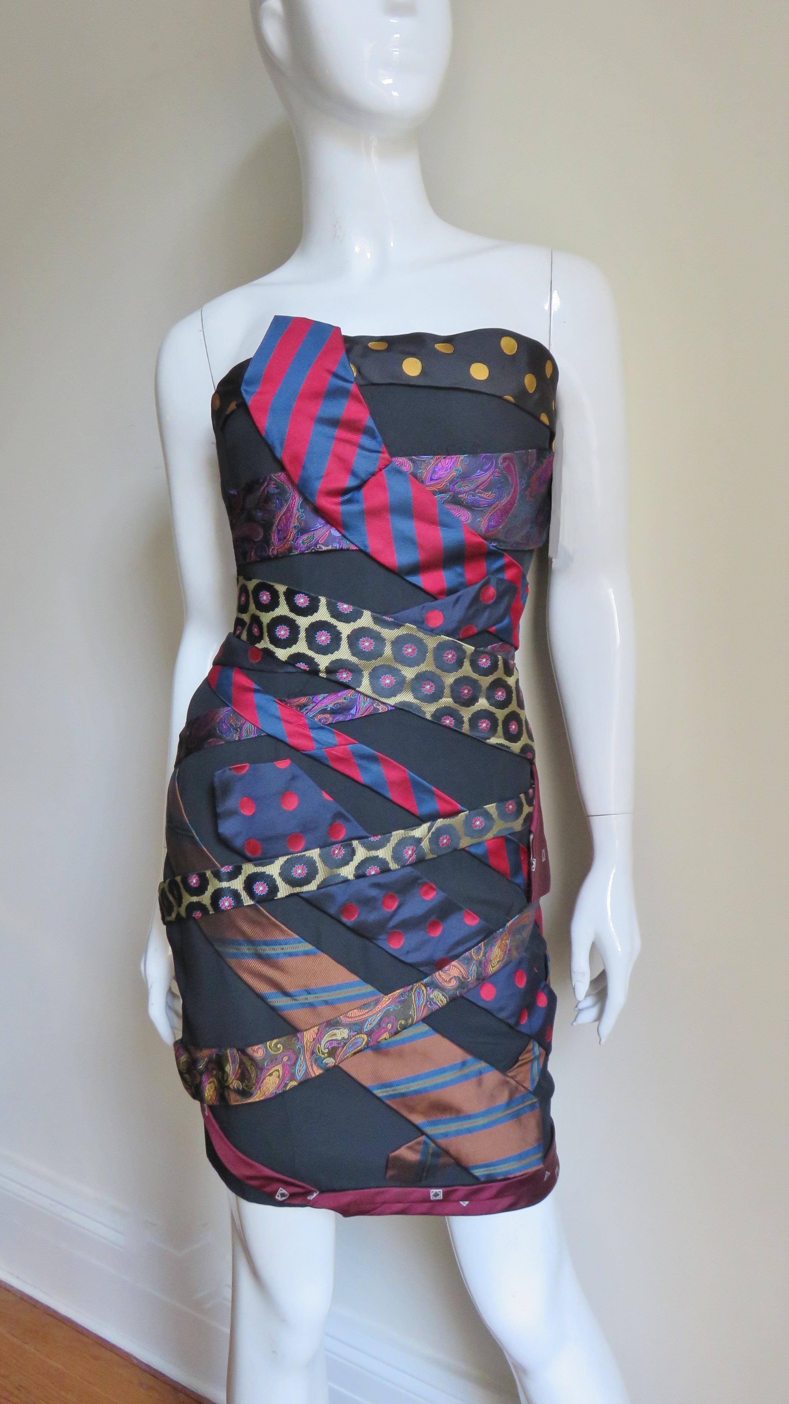 A fabulous whimsical dress from Moschino Couture covered with silk neckties wrapped around the body at varying angles and patterns in blue, red and black. It is a strapless with a boned bodice, side invisible zipper and full lining.   
Fits sizes