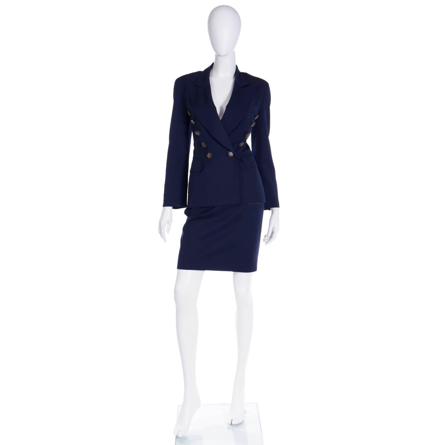 This vintage 1990's Moschino Couture navy blue skirt suit was designed by Franco Moschino and it includes a pretty cinched waist jacket with a slim skirt. The jacket: is double breasted, but most of the buttons are decorative except for the 2