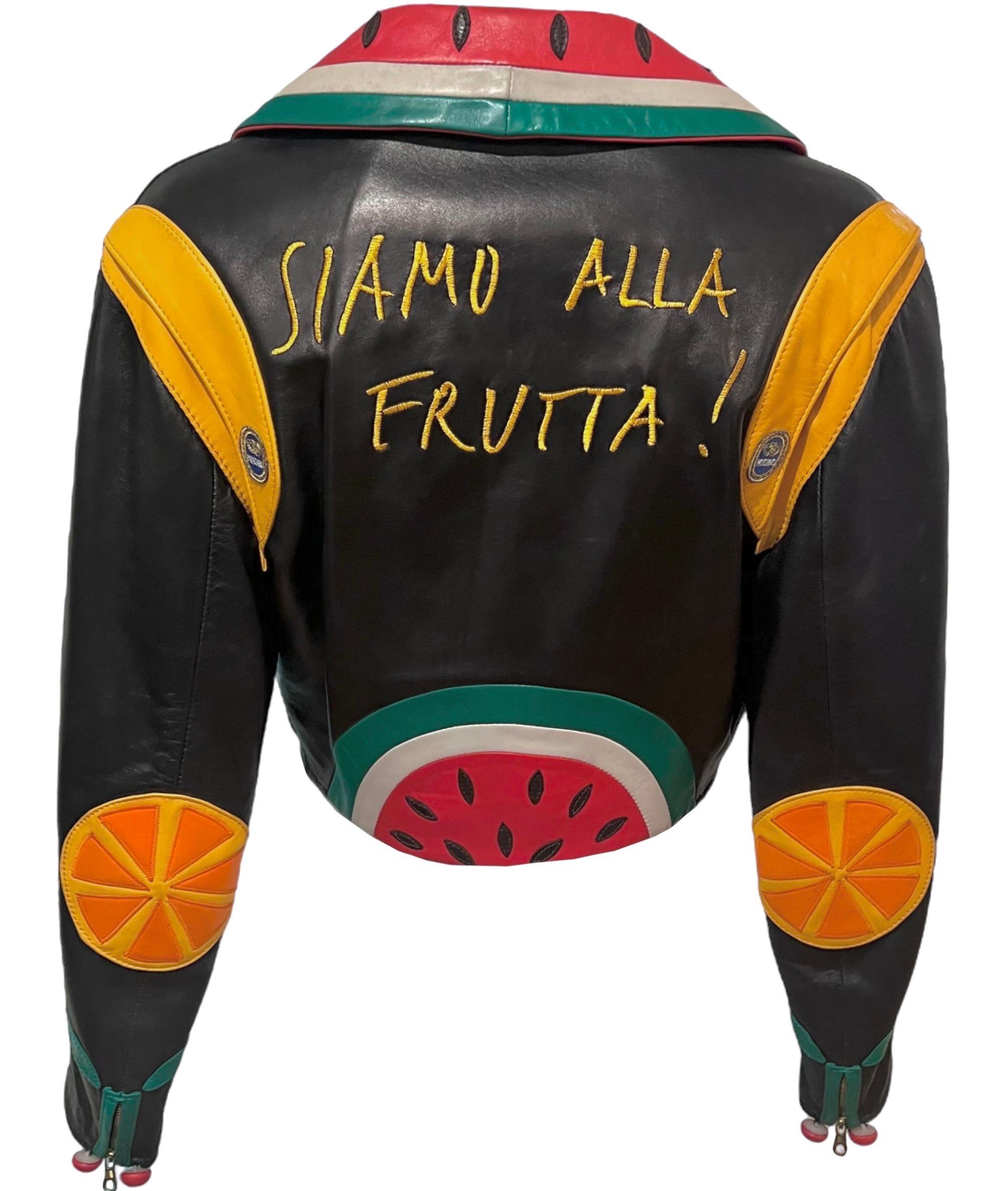 Whimsical rare vintage Moschino black cropped moto leather jacket with colorful fruit appliques. This unique jacket features a watermelon collar, cherry zip pockets, oranges, cherry cuffs, and bananas.
Embroidered with 