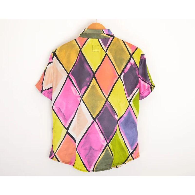 Chic Vintage Moschino 1990's short sleeved 'Harlequin' satin feel shirt in Colourful Jewel tones. 

Features:
Short sleeves
Fitted Shape
Central line button fasten
100% Polyester

MADE IN ITALY

Sizing: Pit to Pit: 20''
Nape to Hem: 27''
Recommended