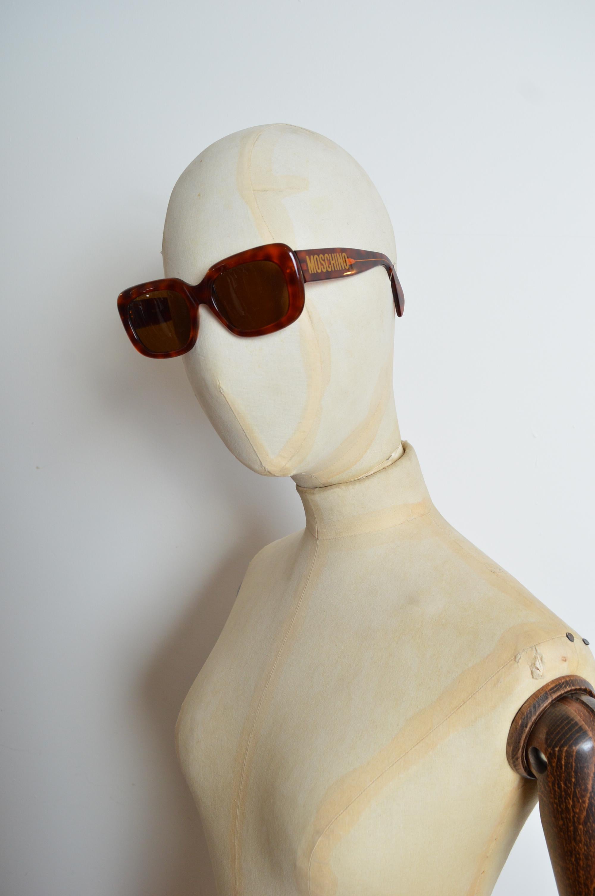 Limitierte Auflage der Moschino x Persol Collaboration der frühen 1990er Jahre Sonnenbrille aus schildpattfarbenem Acryl mit  geprägter Schriftzug in Gold an den Bügeln und braun getönte Gläser.
Größe - Einheitsgröße / Standard
Maße in