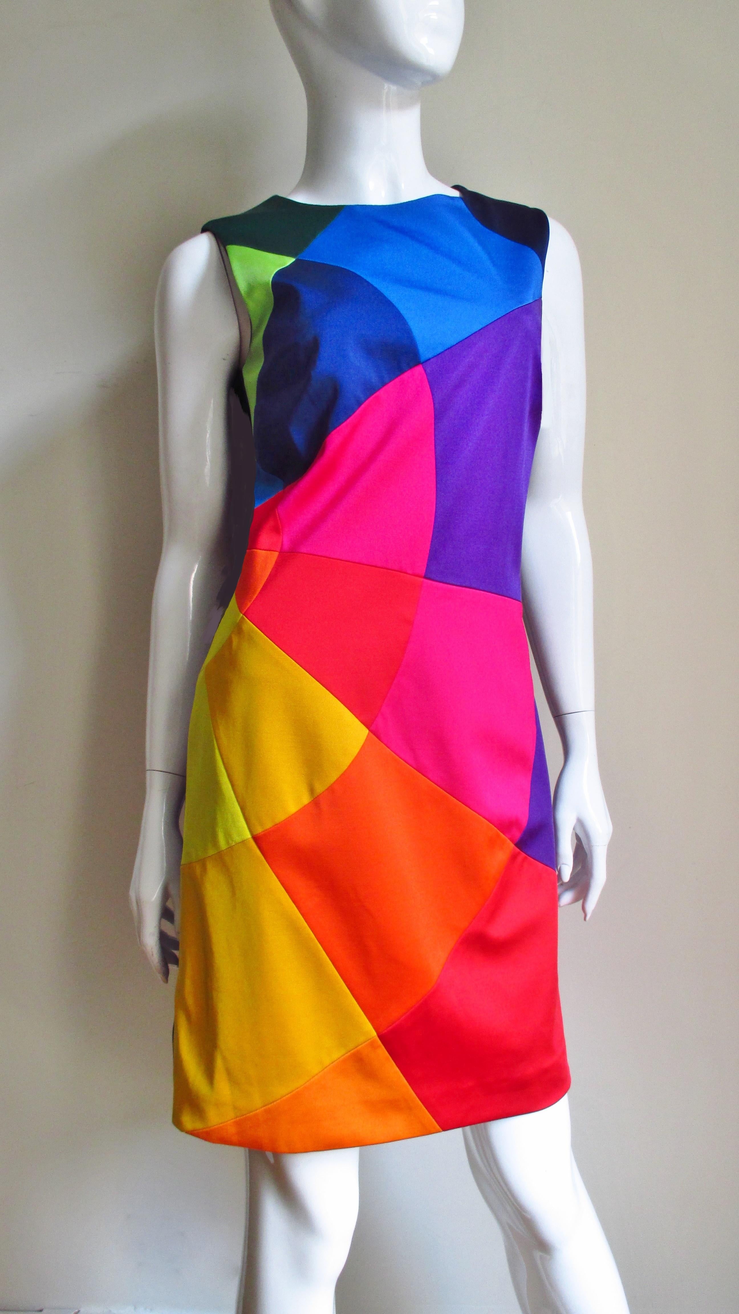 A fabulous colorful dress with a bit of stretch from Moschino.  It is is sleeveless with a crew neck and incredible brightly colored shapes each individually sewn together comprising the front of the dress, the back is solid black.  It is lined in