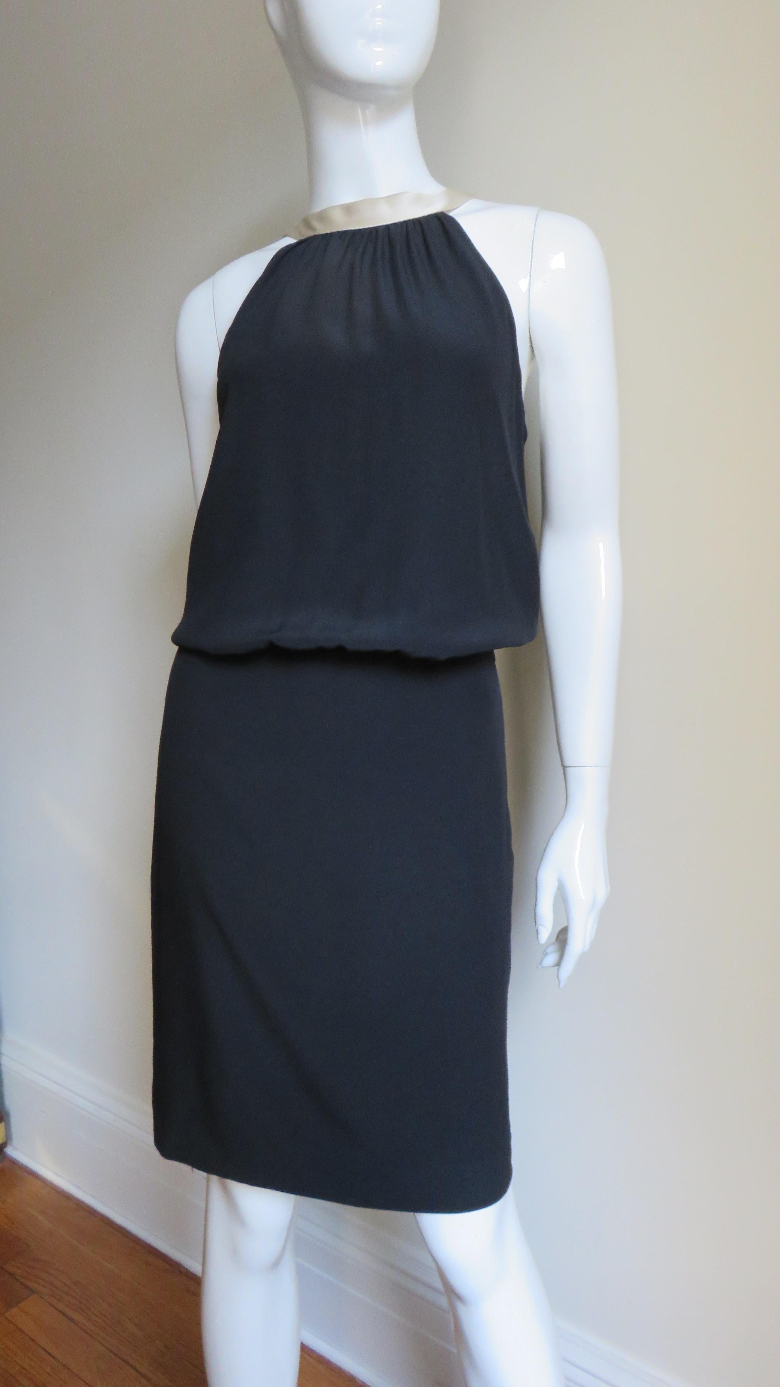 A fun, fabulous black silk dress from Moschino.  It is a sleeveless with a draped bodice and straight skirt.  The scoop back is adorned with a functional off white silk necktie extending down the center back.  Fabulous.  It is fully lined and has a