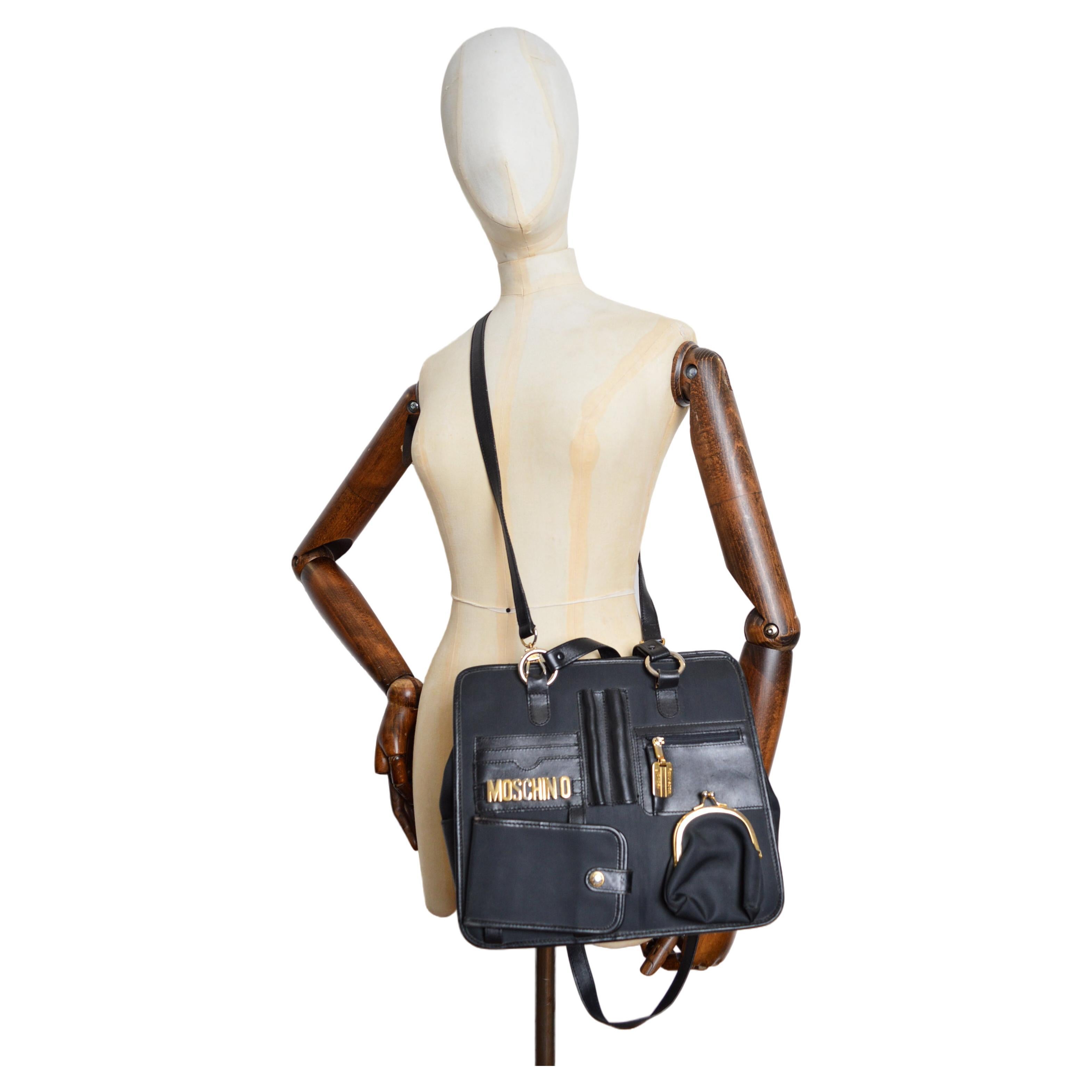 A Superb, archival Vintage Moschino Bag circa 1990 constructed from a Black Nylon cloth with Black leather trim and Gold tone metal hardware details, produced by REDWALL.  

MADE IN ITALY.  

Features ; Two shoulder strap handles, Detachable body
