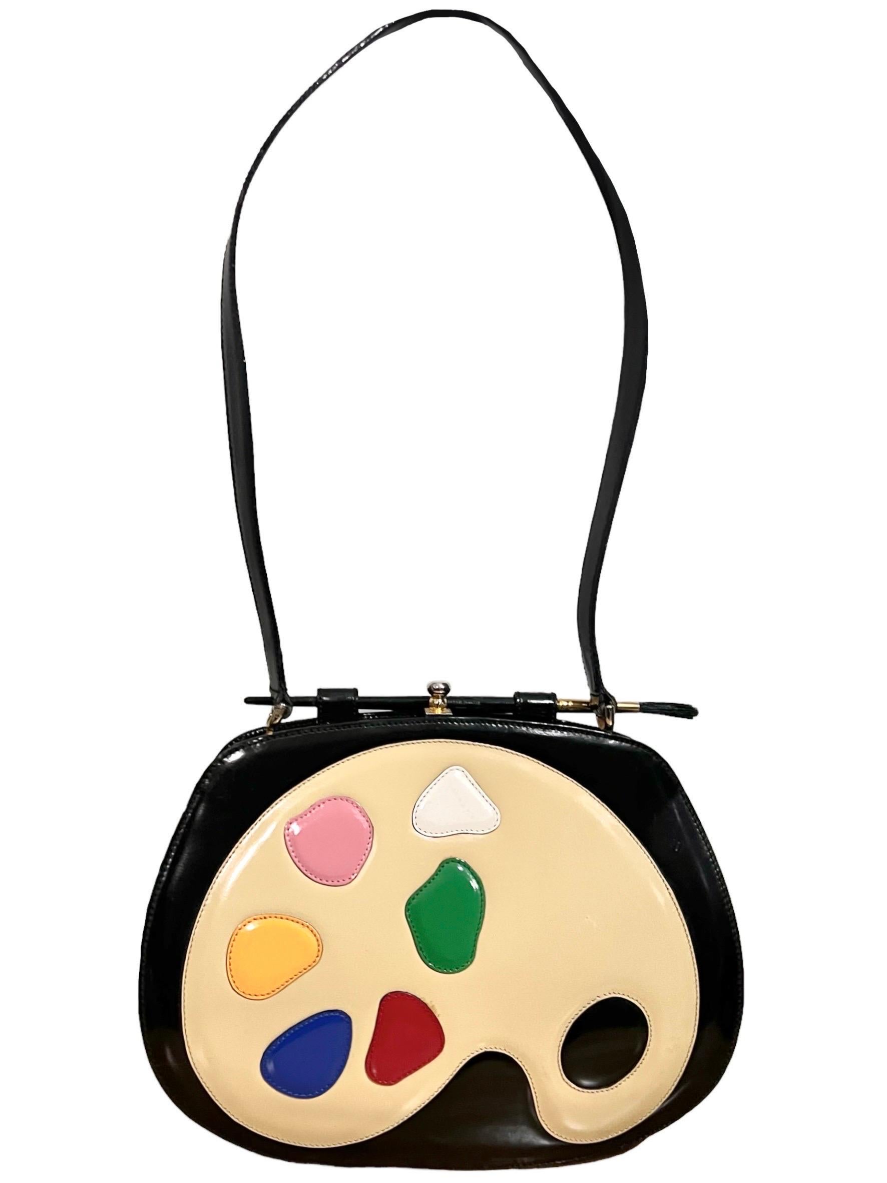 Vintage Moschino Redwall artist palette patent leather shoulder bag
Designed as an artists palette complete with a real paintbrush adorning the top of the bag.
Made of shiny patent leather.
Interior lined with jacquard fabric with one zipper pocket