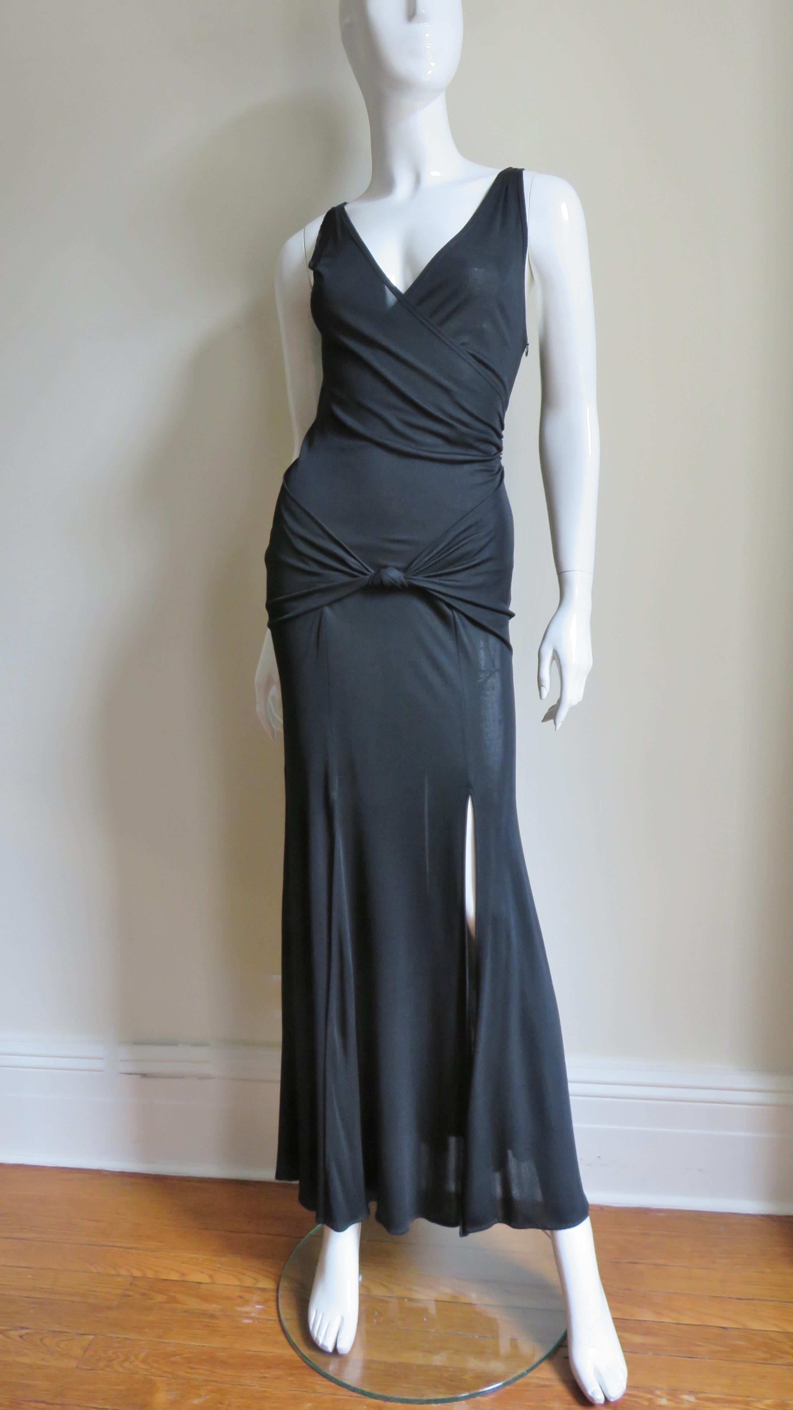 A great dress in black light weight jersey from Moschino.  It is maxi length with a wrap bodice, ruched knotted hip band and fabulous carwash detail by way of 6 thigh high panels at the hem.  It is unlined and has a side zipper.  
Appears unworn. 