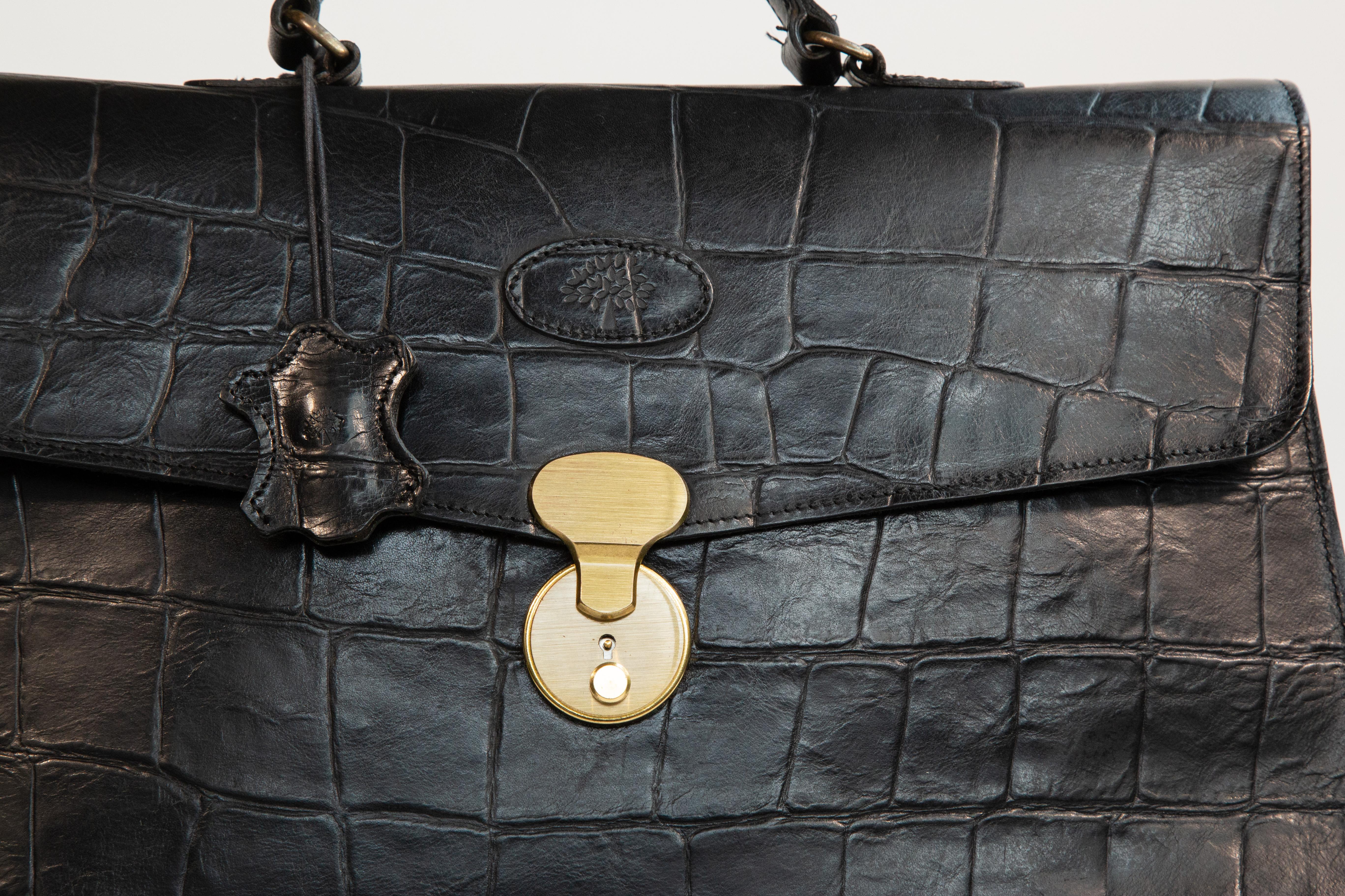 Borsa per laptop/documenti Mulberry in pelle nera del Congo con motivo a coccodrillo in rilievo. La ferramenta è in ottone. L'interno è foderato in pelle scamosciata nera ed è composto da due scomparti principali. Inoltre, c'è una tasca laterale con