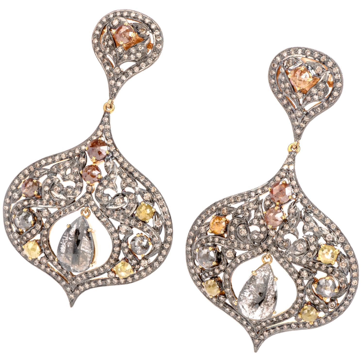 These grand statement dangle drop earrings crafted in silver and 14k gold. it  showcases an elaborate and elegant design that highlights two dangling pear cut diamonds. These fashionable earrings are set with an array of multicolored rose cut