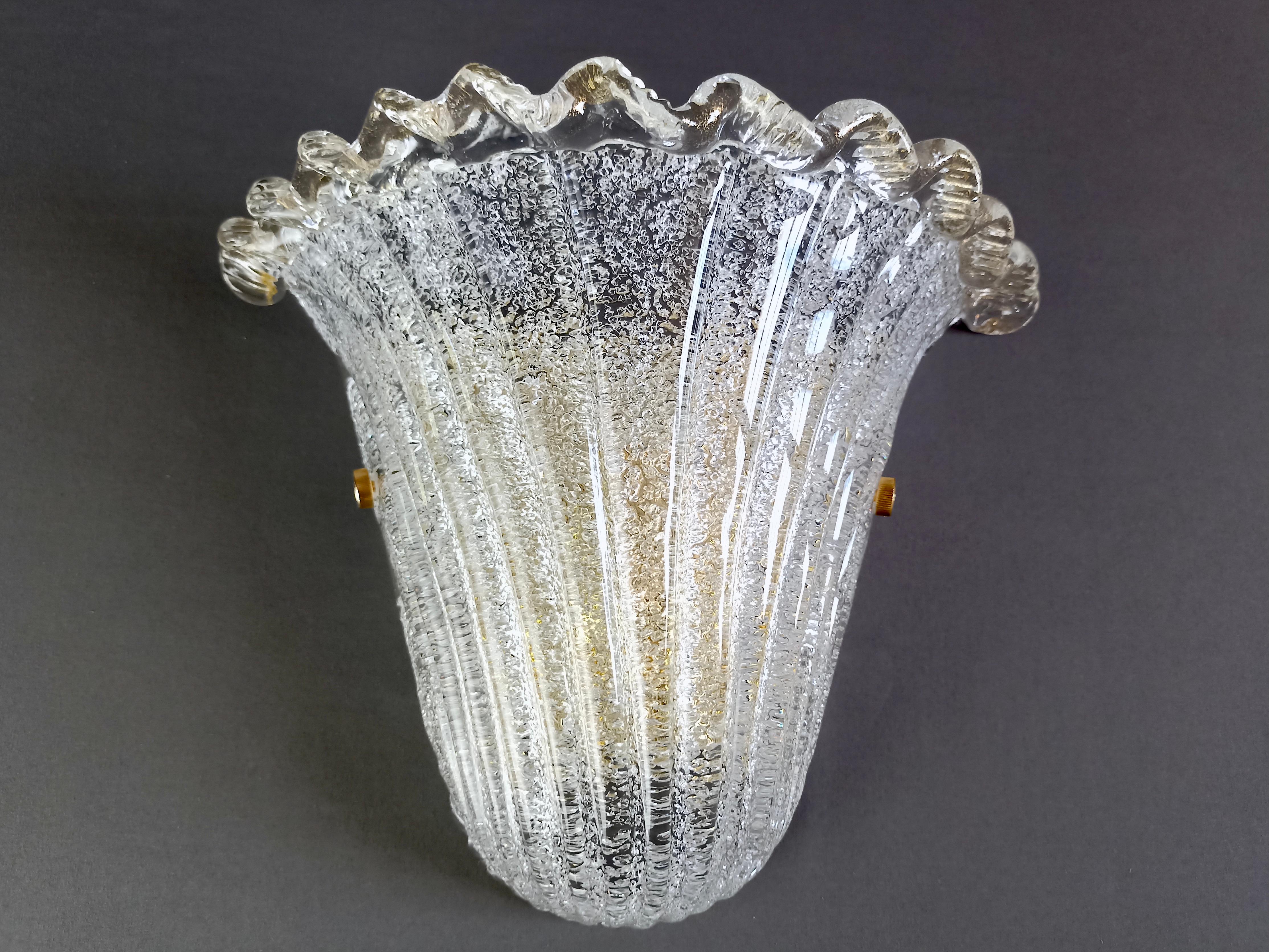 Fascinating 1990s Murano art glass shell wall lamp in Barovier's classic Venetian style. 
The clear, smooth ribbed glass lampshade features a stunning effect, achieved by the hot application of dense, minute flakes of glass in the inner parts,