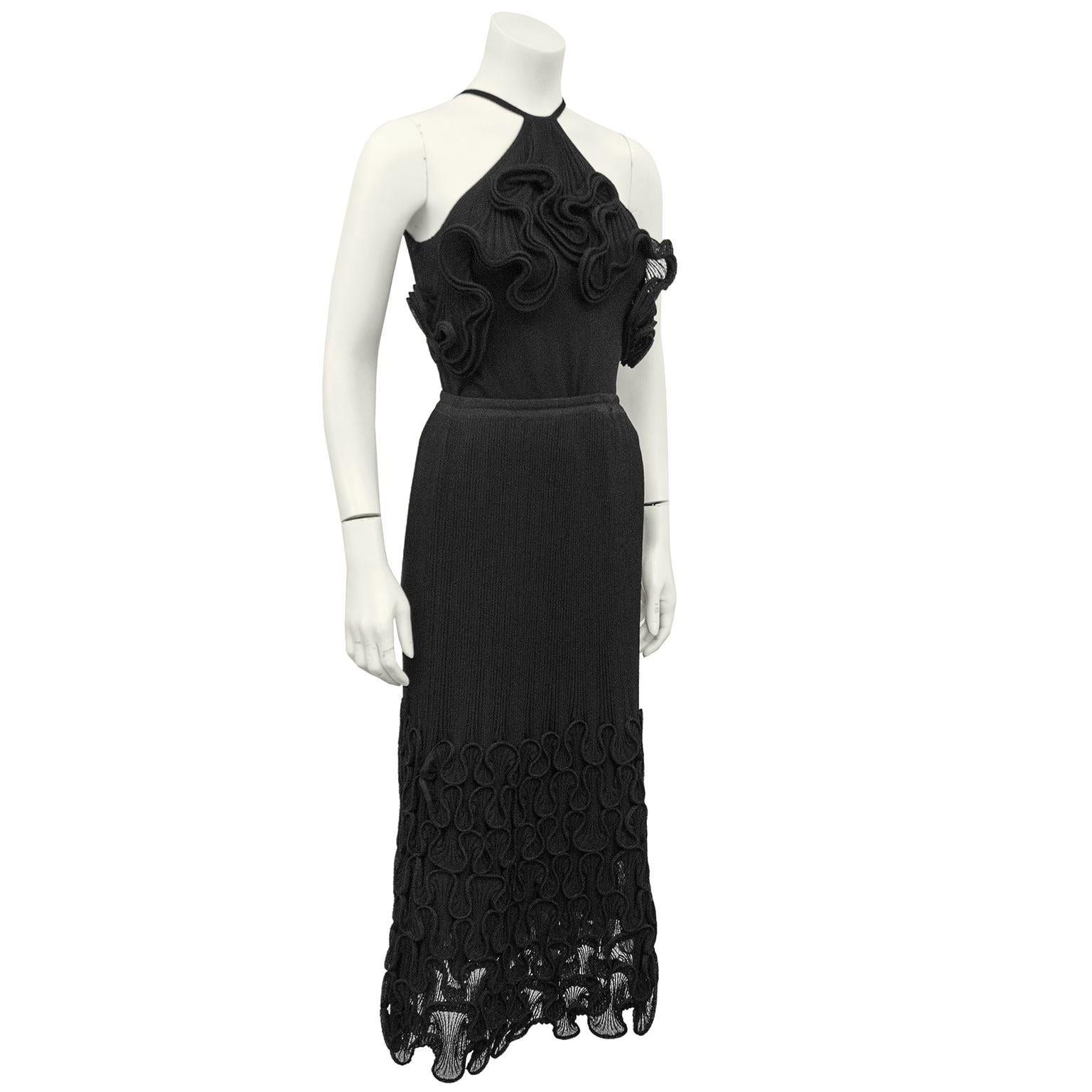 The French designer, Nora Attalai, is best known for her exquisite knits, like this 2 piece skirt ensemble. The black halter style top is knit from a very fine fabric and features her signature wavy knit frills on the front at the bust. The matching