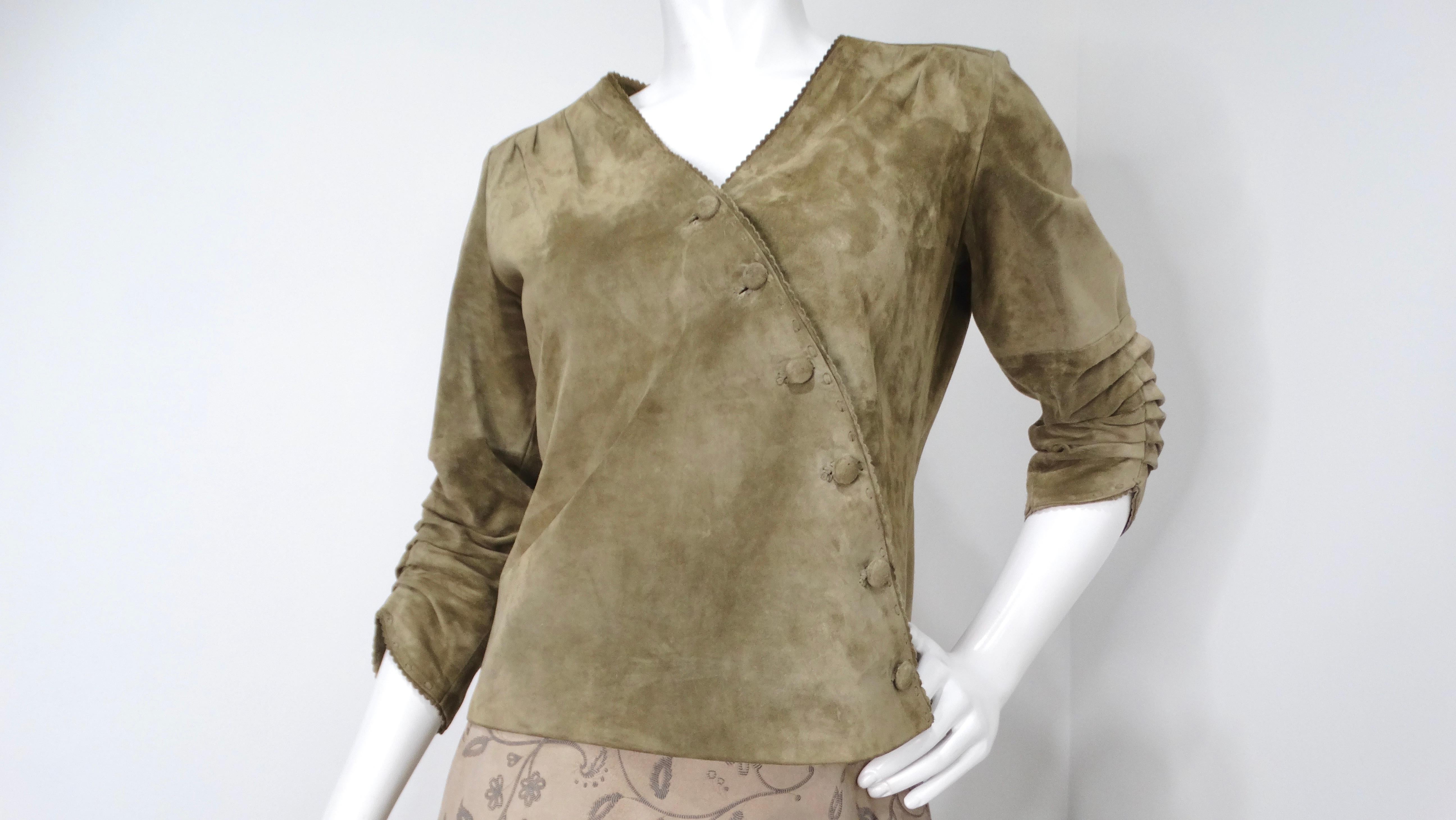 Introducing a stunning 1990s olive green suede wrap jacket, a timeless piece that merges vintage elegance with modern versatility. Crafted from luxurious suede, this jacket features a chic wrap design that cinches the waist, creating a flattering