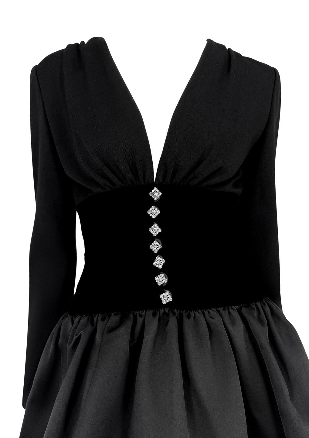 This Oscar de la Renta mini dress from the 1990s features a plunging neckline and a structured black velvet bodice adorned with rhinestone buttons, creating a striking focal point. The satin skirt flares out gracefully, adding volume and movement,